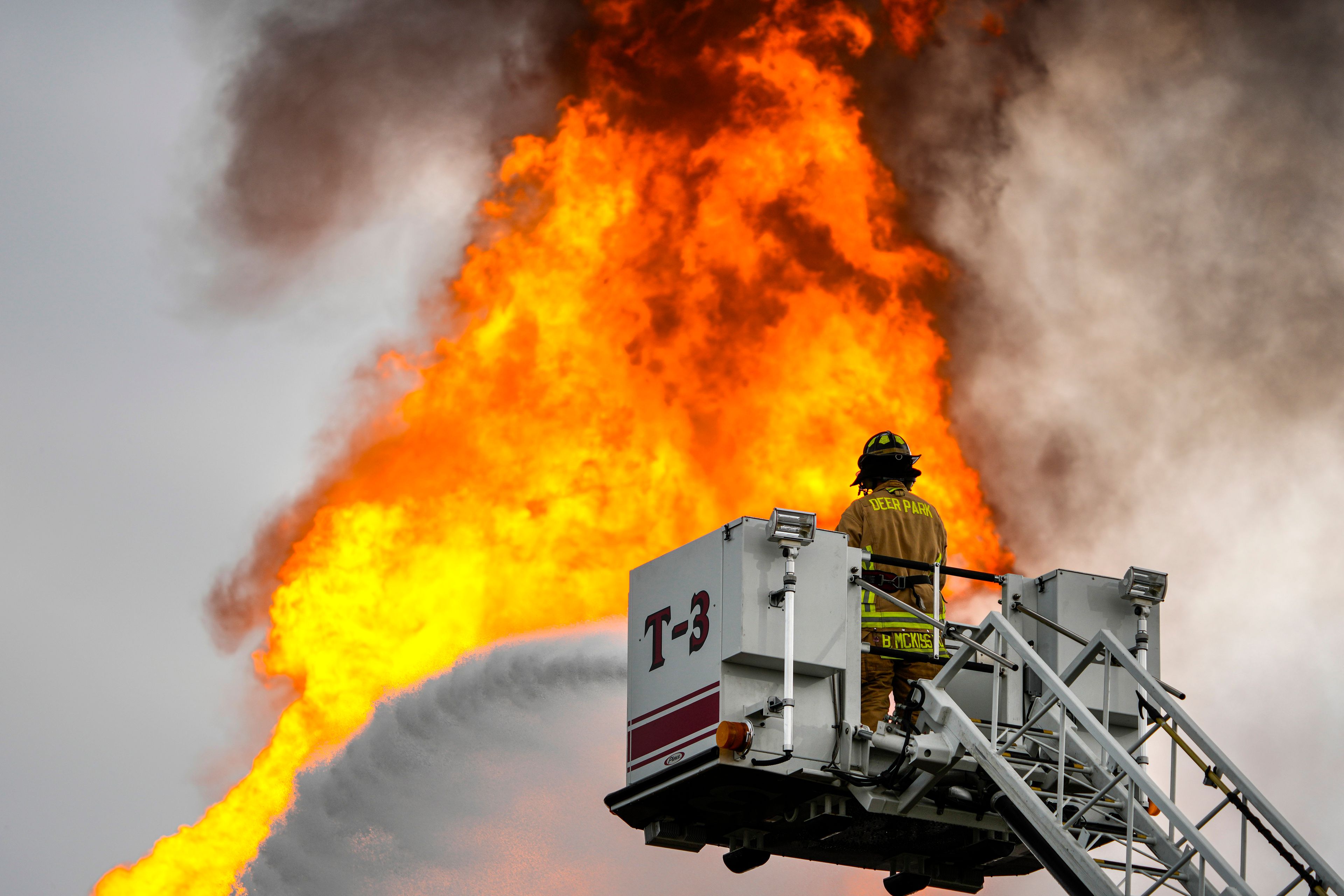 A firefighter directs a line of water around a fire on a pipeline carrying liquified natural gas near Spencer Highway and Summerton on Monday, Sept. 16, 2024, in La Porte, Texas. (Brett Coomer/Houston Chronicle via AP)