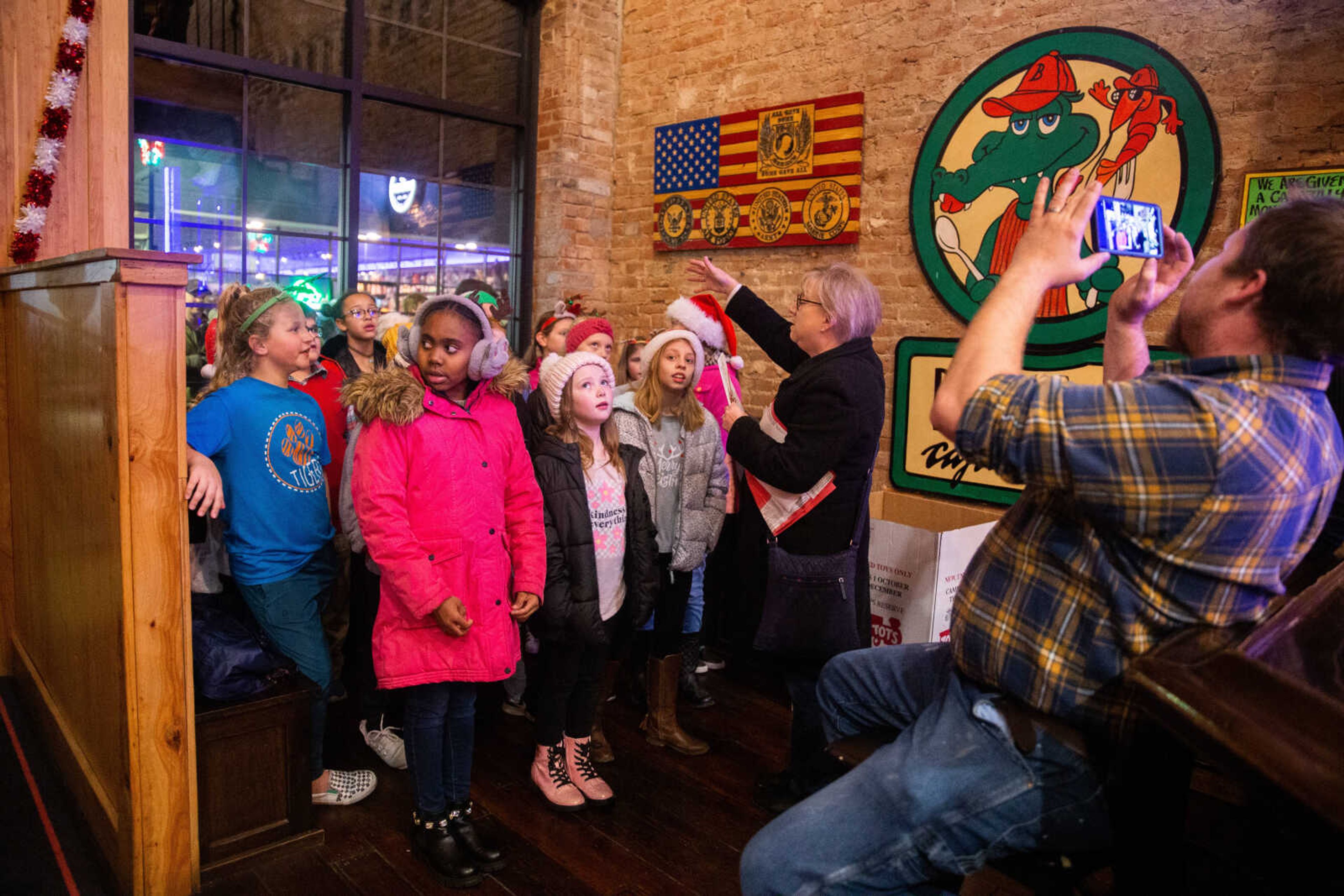 Rebecca Gentry leads the 4th grade choir from Alma Schrader Elementary School as they carol inside Boussard's&nbsp;on Friday, Dec. 2 in downtown Cape Girardeau.