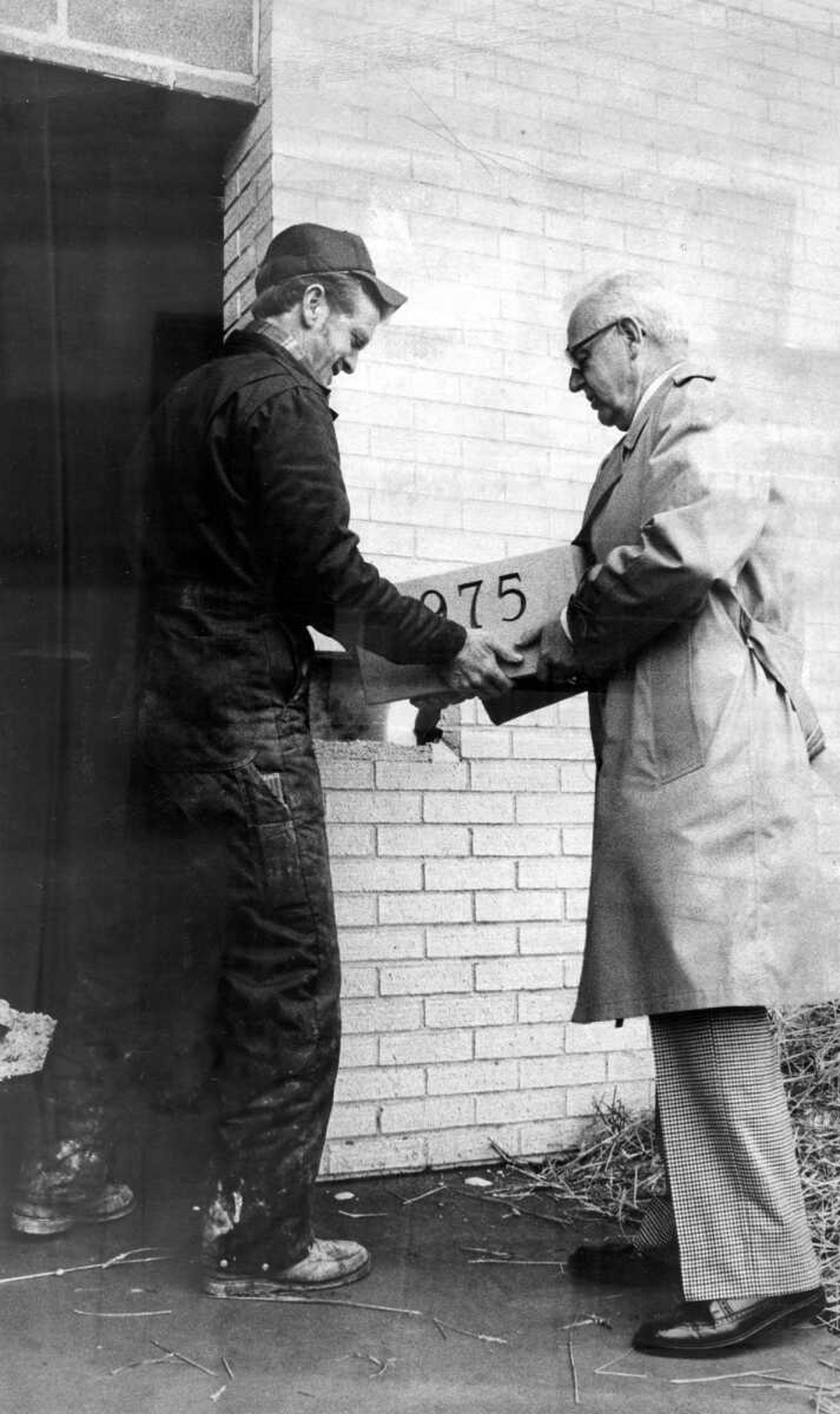 Cape Girardeau Police Chief Henry H. Gerecke, right, places the cornerstone into position in the new police headquarters building on January 2, 1976, with the help of Jerald Williams of Jackson, representing Bricklayers Local 23. The cornerstone contains current information on the police department.