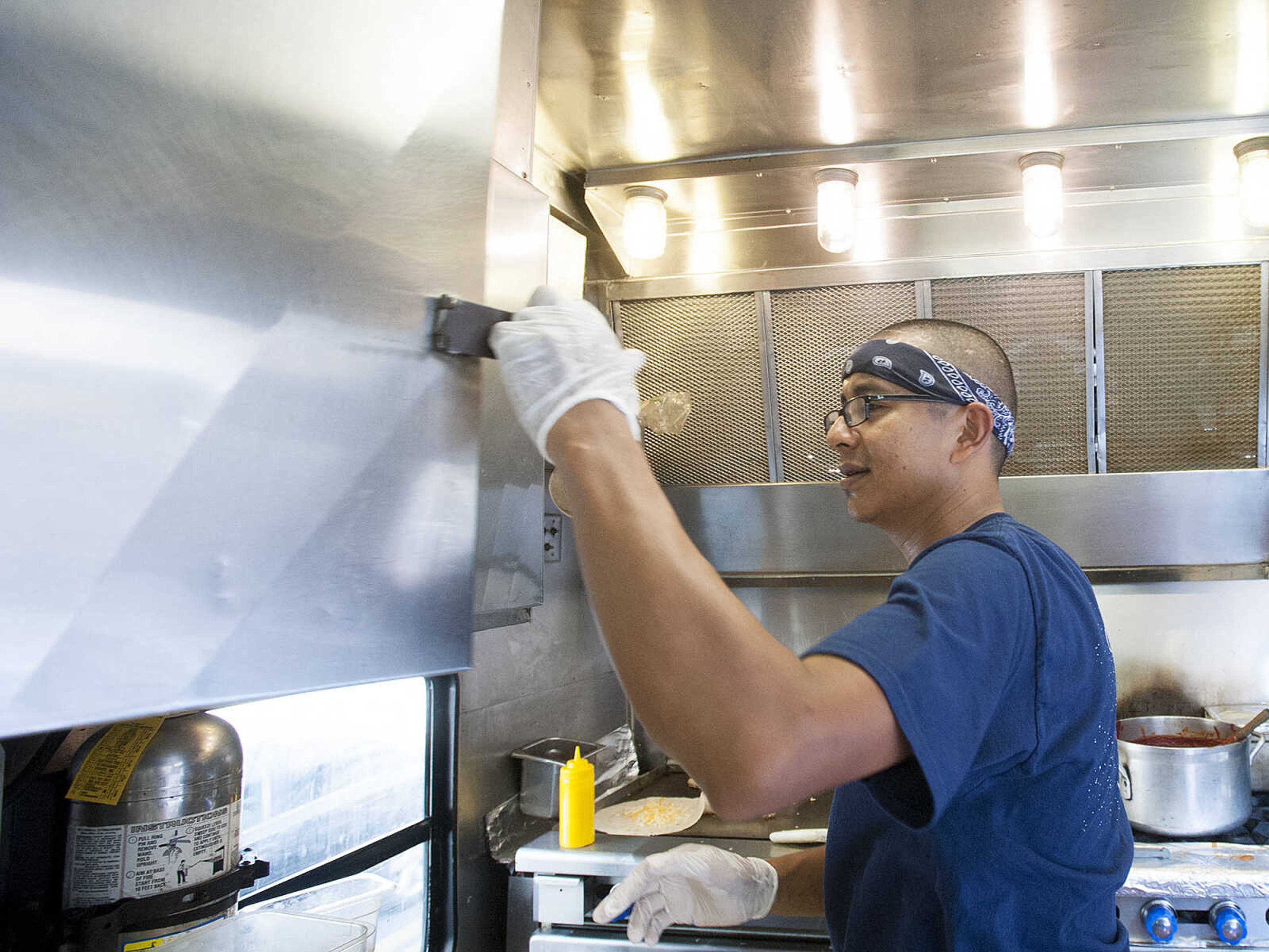 ADAM VOGLER ~ avogler@semissourian.com
Oscar Rodriguez of Palmdale, Calif., makes breakfast burritos and burgers for the cast and crew of the 20th Century Fox feature film "Gone Girl," Thursday, Oct. 3. For Stars Catering, which is based in Carlsbad N. M., is serving meals to up to 120 people each day.