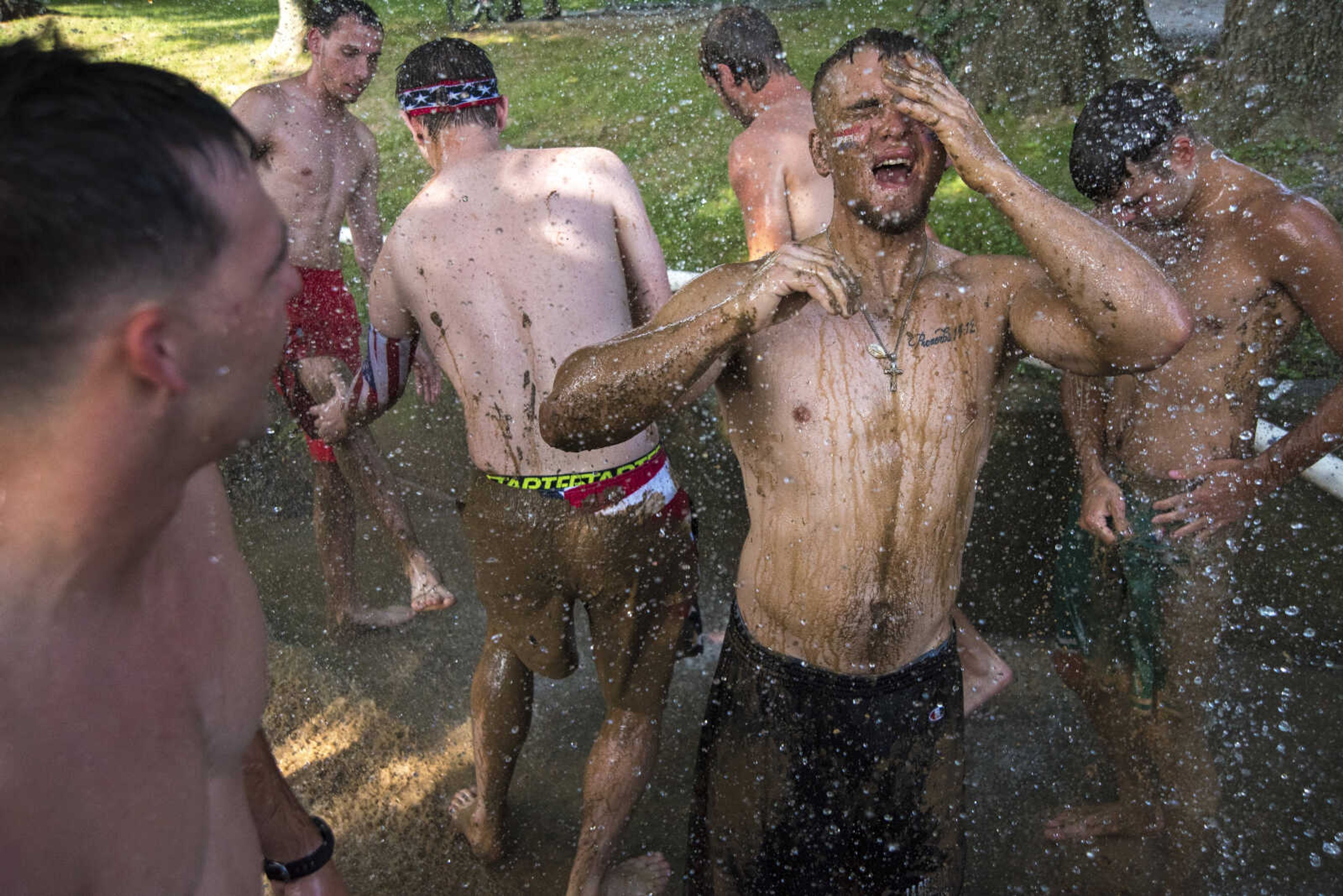 Ryan Baker, right, washes off mud after playing mud volleyball for the Jackson Parks and Recreation's July 4th celebration Tuesday, July 4, 2017 in Jackson City Park.