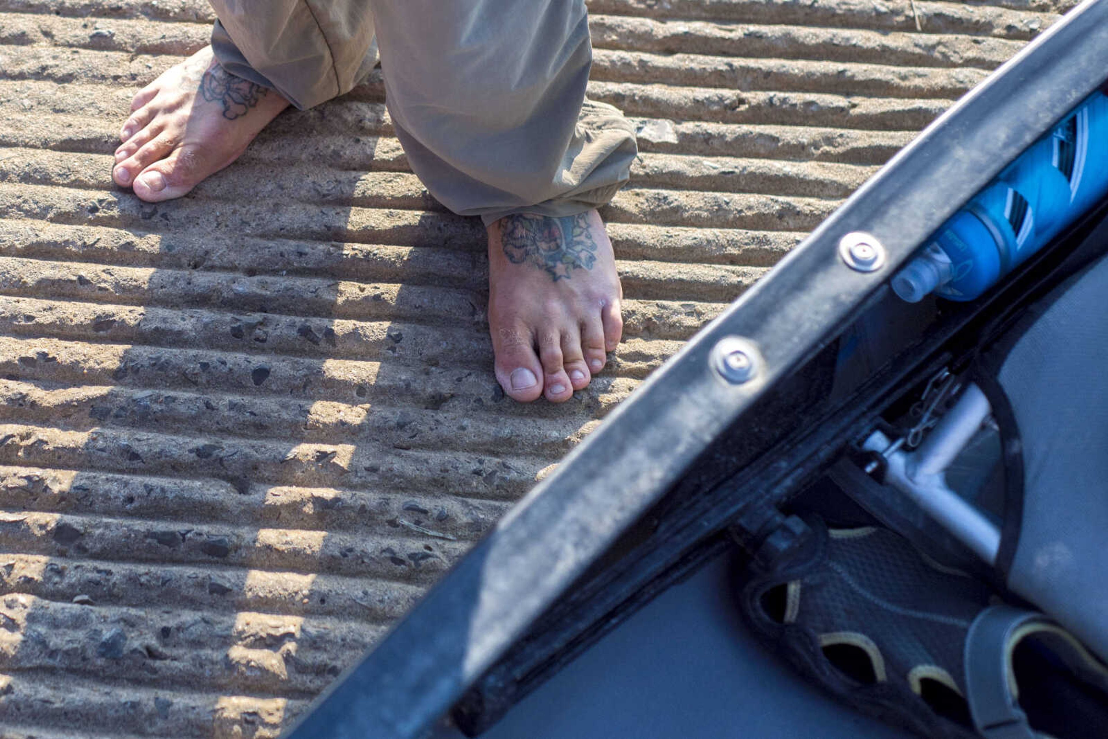 Army veteran Matt Roy's tattooed feet are seen Tuesday morning at the Red Star dock as he prepares to continue his trip down the Mississippi River to New Orleans.