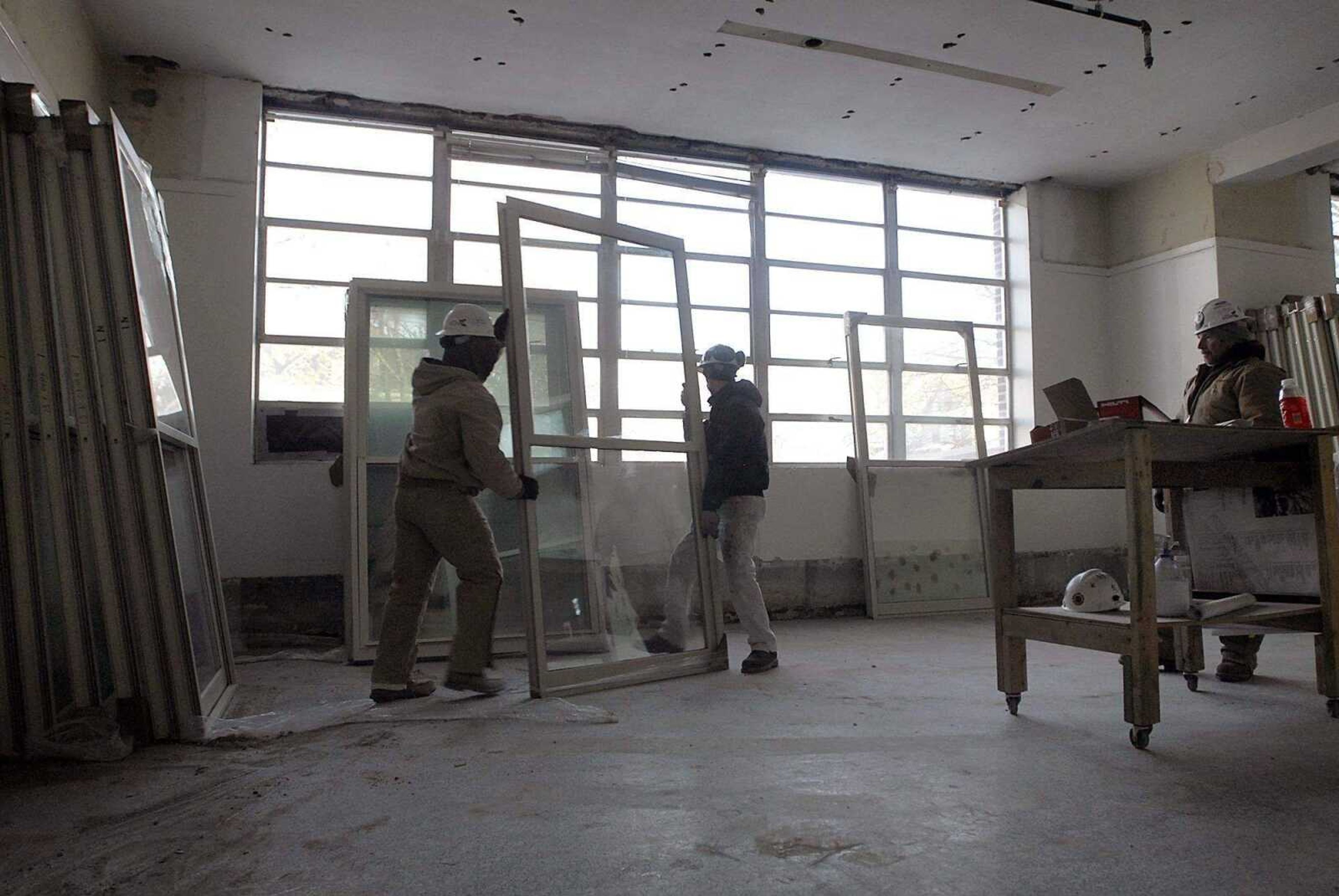 KIT DOYLE ~ kdoyle@semissourian.com<br>Chris Sturk, left, and Tim Ziegler move exterior windows Feb. 3 that will replace the school windows in a former classroom in the old Schultz School building in Cape Girardeau. Renovating the Schultz building is part of the DREAM Initiative.