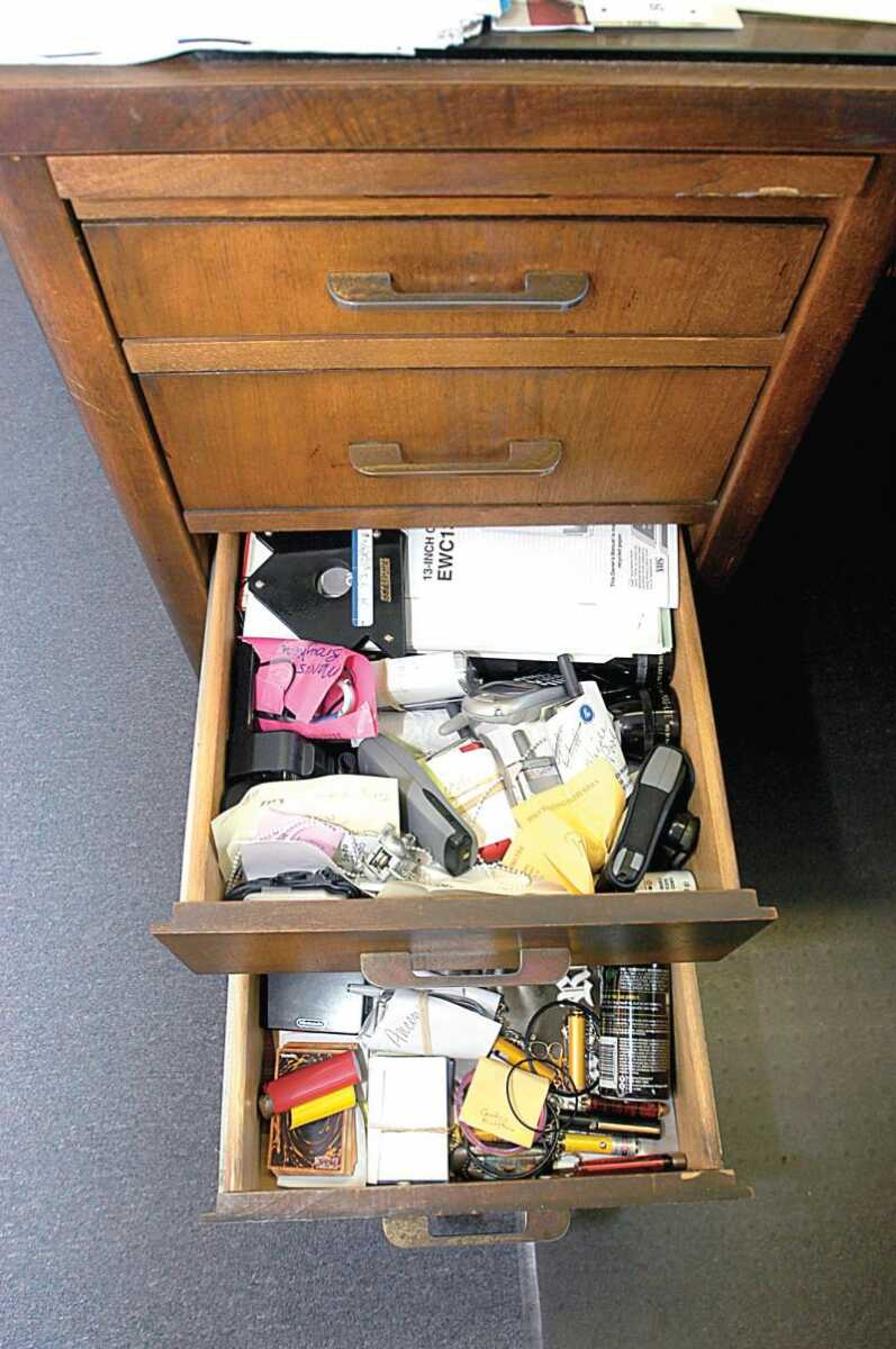 Cell phones and other gadgets are waiting for the owners to claim in the desk of Brenda McCowen at Central Junior High School.