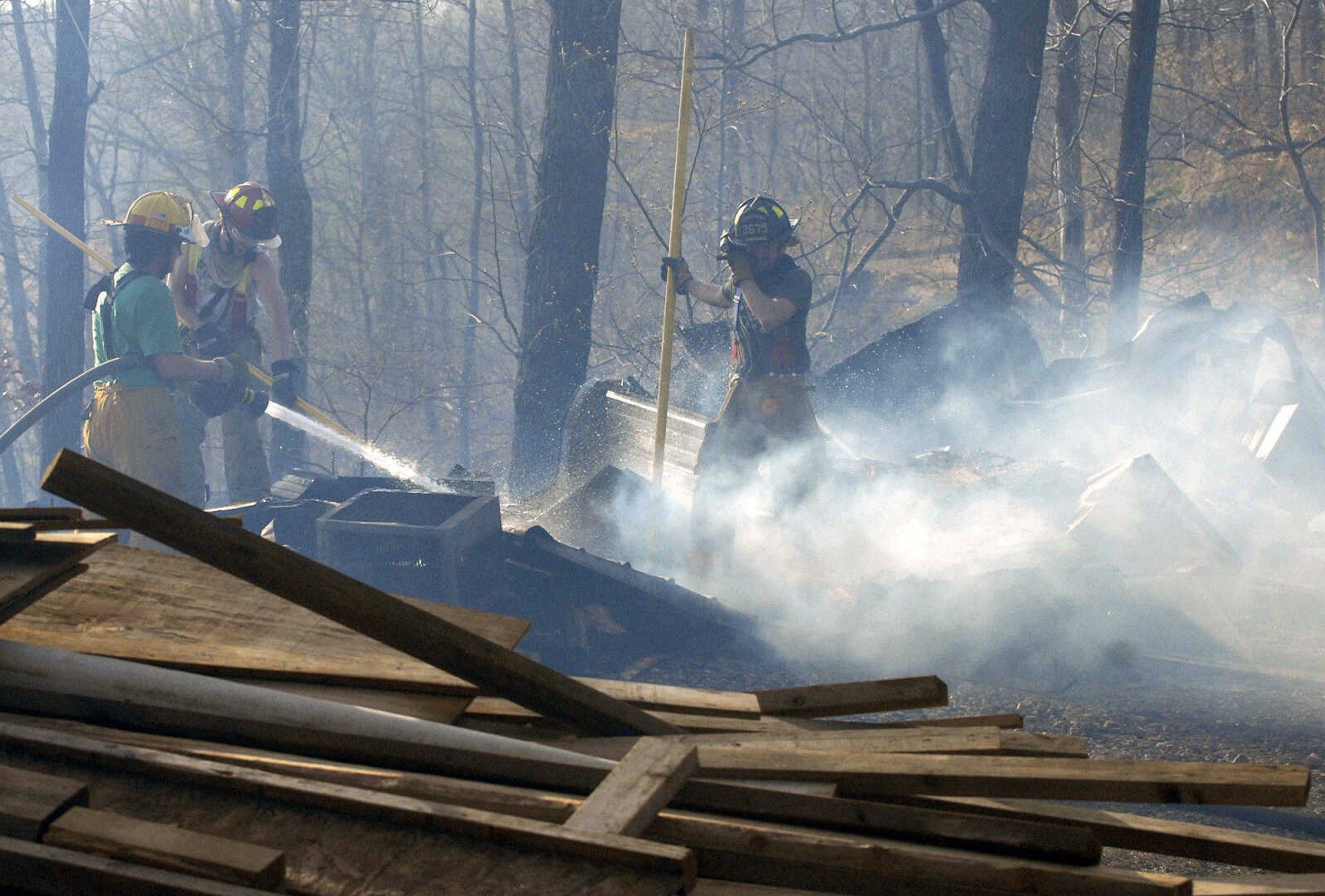 LAURA SIMON~lsimon@semissourian.com
Fire crews extinguish fire on the rubble of a shed that burned to the ground during a natural cover fire off of Cissus Lane in rural Cape Girardeau County Sunday, April 3, 2011. Firefighters from Cape Girardeau, Perry, Scott, and Bollinger Counties contained the blaze that ravaged 50 acres of land.