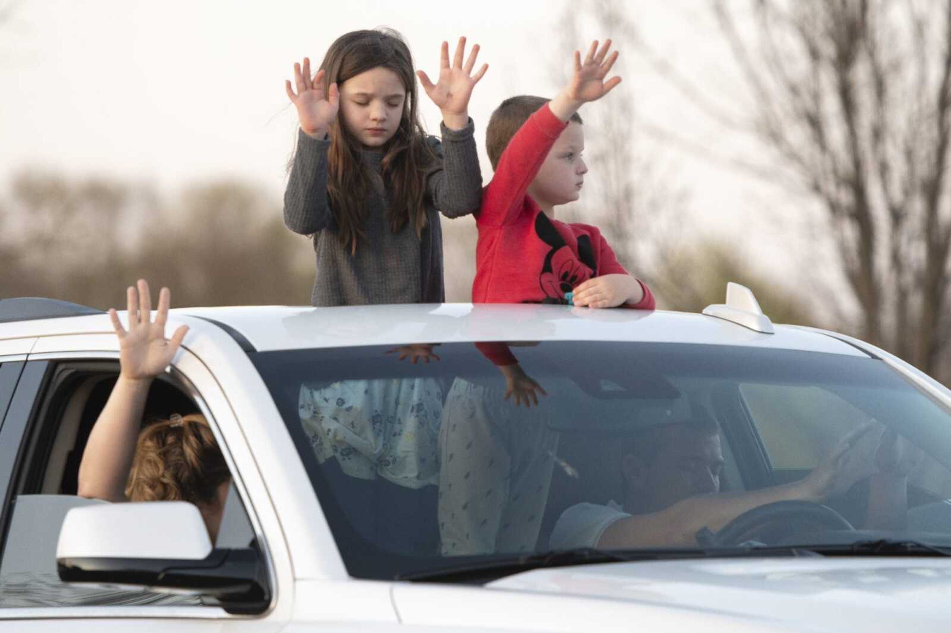 Statler siblings Bella, 7, and Carter, 4, of Oak Ridge, take part in a "park and pray  event with their parents Paige and Rusty Statler, in passenger and driver seats respectively, on Tuesday, March 31, 2020, outside Southeast Hospital in Cape Girardeau.