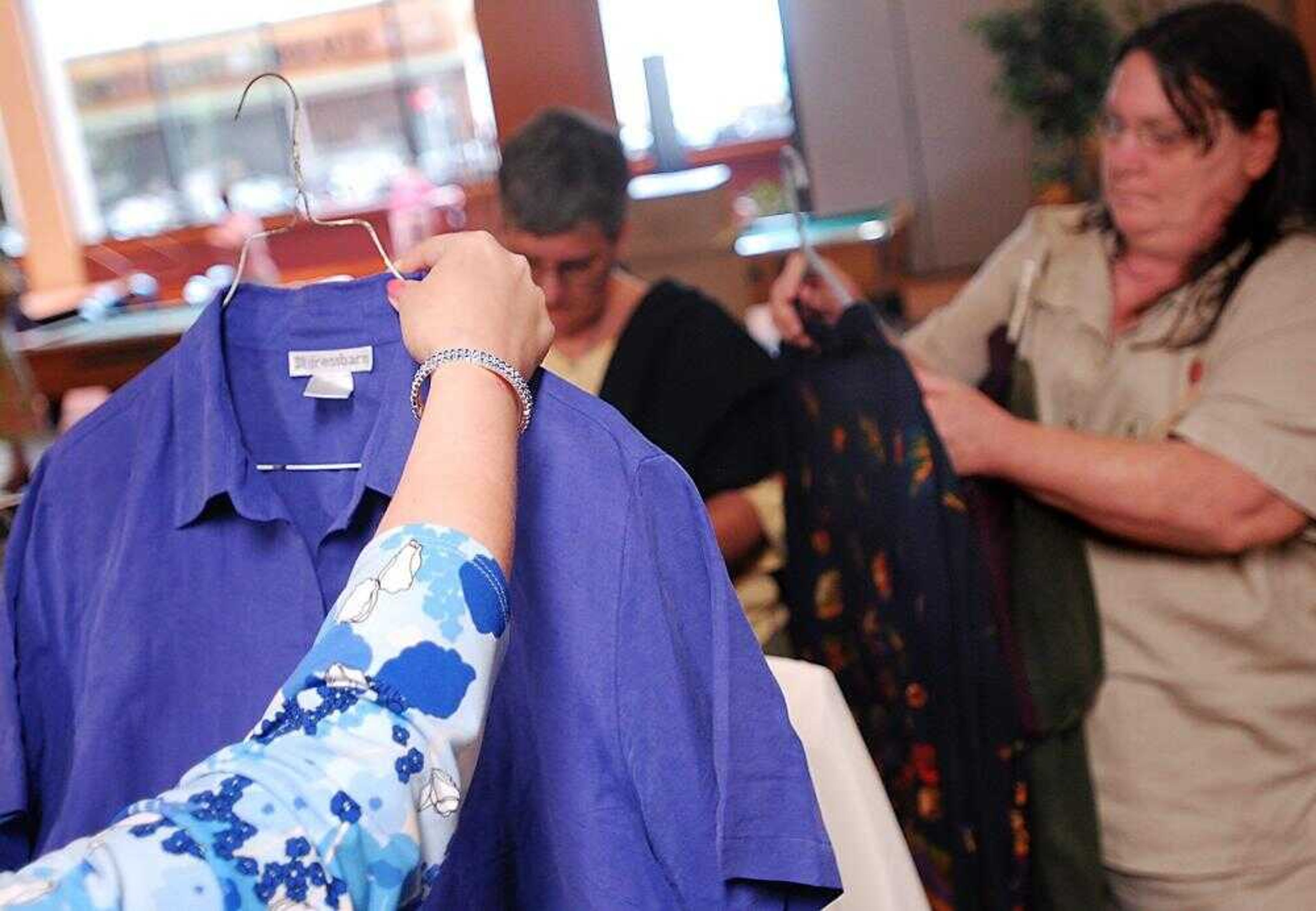 Lora Magill examined a blue blouse Saturday as Mary Schulz looked through other donated workplace-appropriate outfits at the University Center at Southeast Missouri State University. (Aaron Eisenhauer)