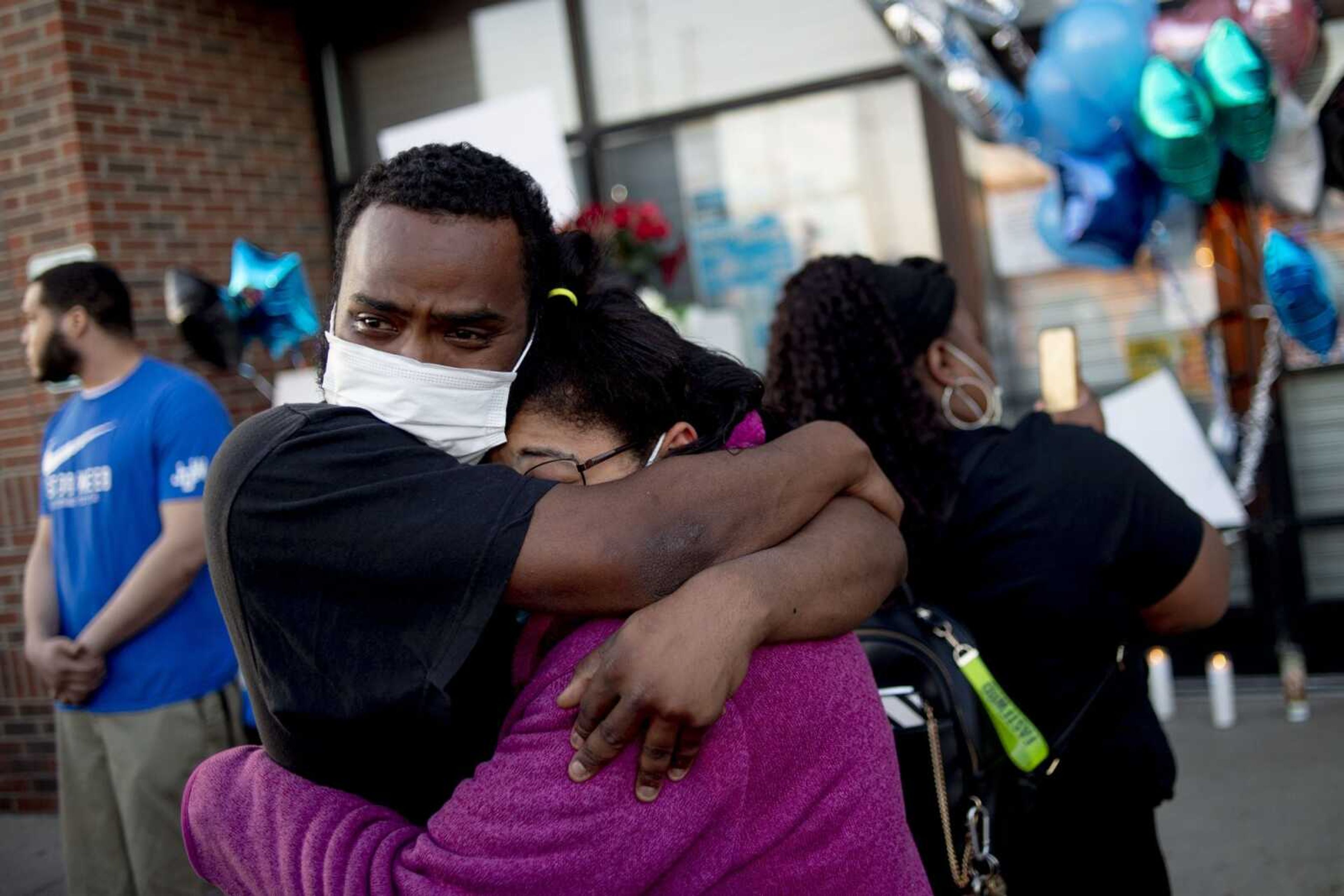 Demonte Munerlyn, son of Calvin Munerlyn, holds his aunt Sharion Munerlyn as the two cope with the death of Calvin Munerlyn, on May 3 in Flint, Michigan. A woman, her adult son and husband have been charged in the fatal shooting of Calvin Munerlyn, a security guard who refused to let the woman's daughter enter a Family Dollar in Michigan because she wasn't wearing a face mask.