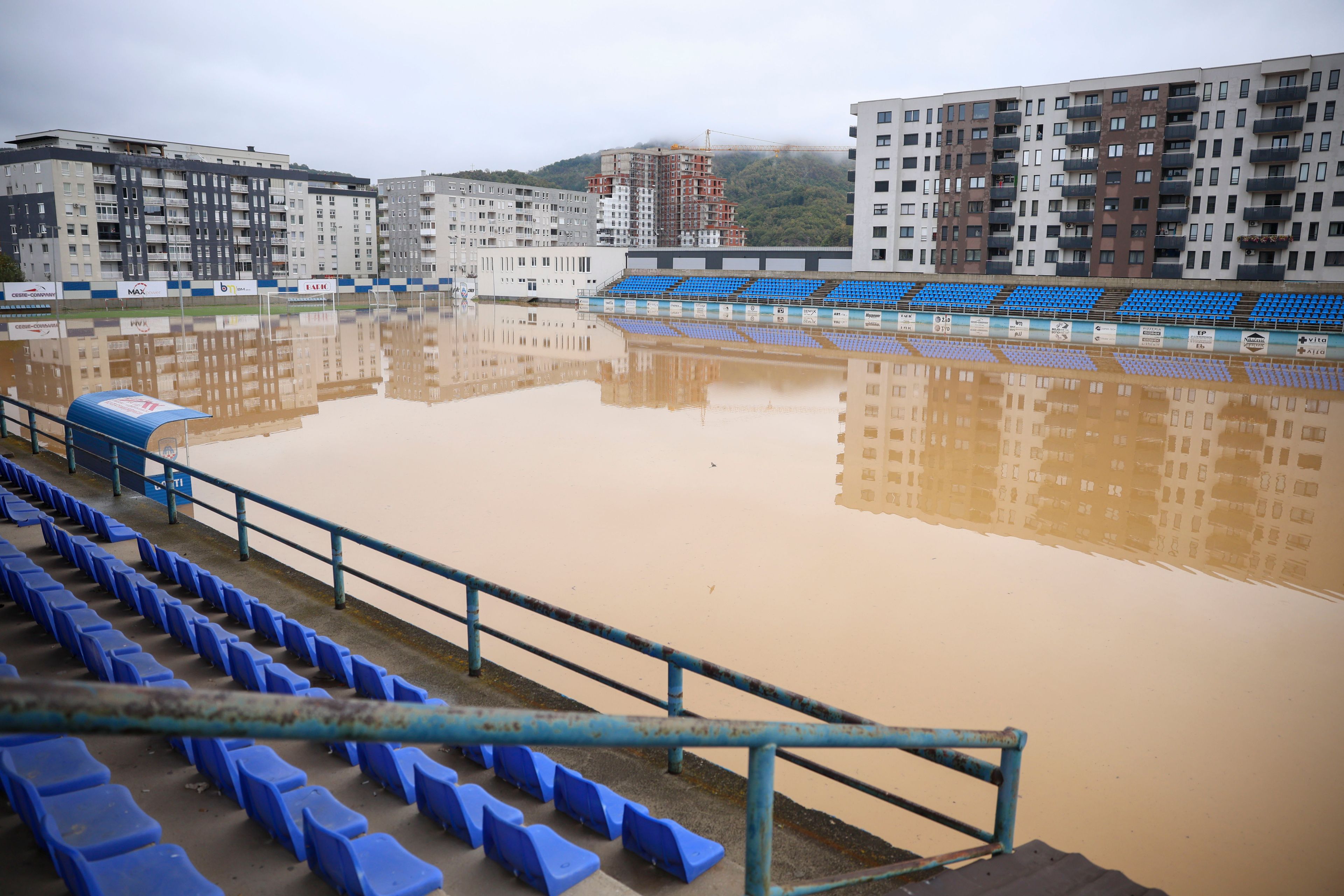 Apartment buildings are reflected at a flooded soccer field after a heavy rain in the village of Kiseljak, northern Bosnia, Friday, Oct. 4, 2024. (AP Photo/Armin Durgut)