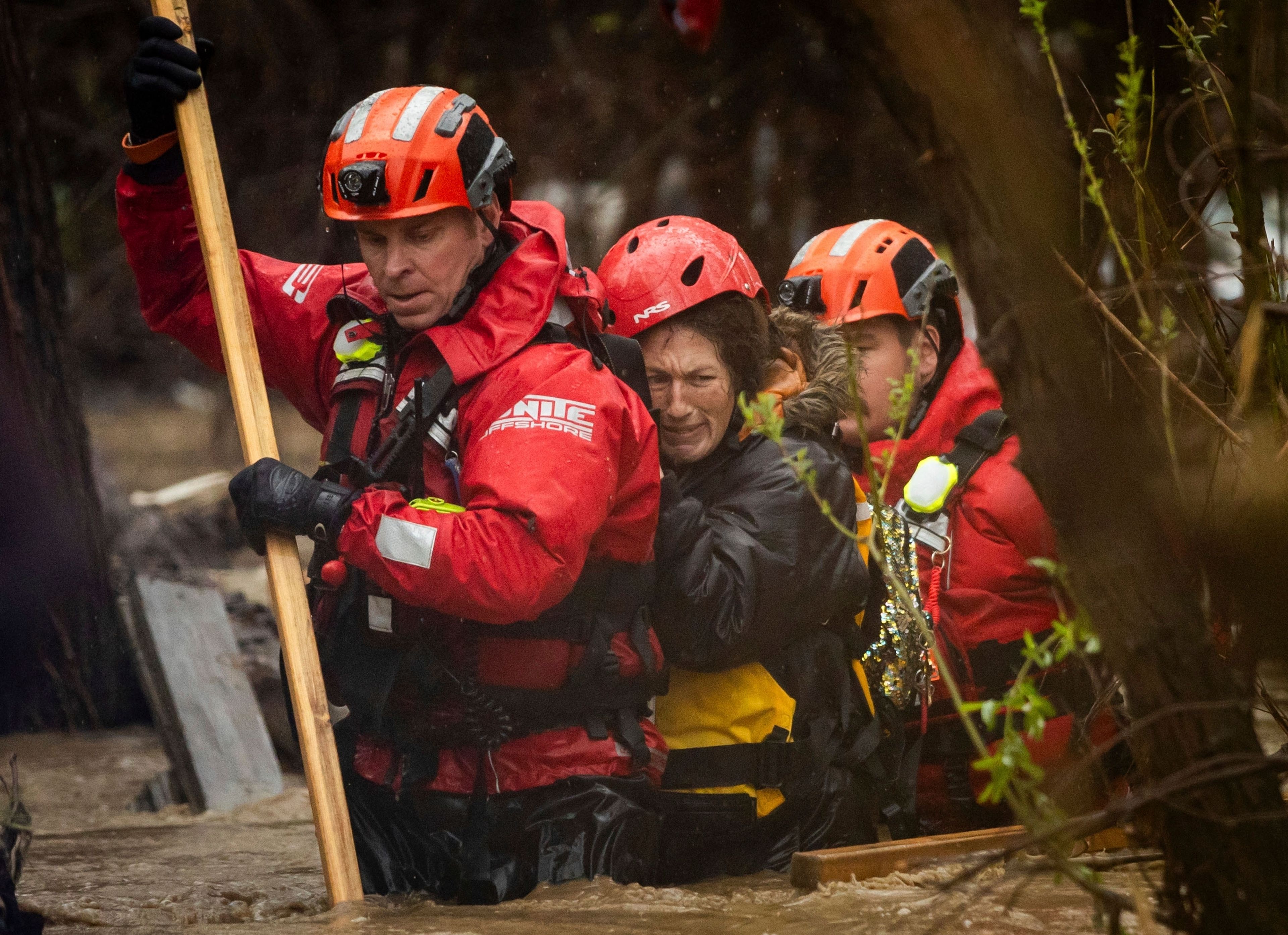 FILE - Firefighters rescue a woman from a homeless encampment that became surrounded by floodwater in the Santa Ana River during a rainstorm, Feb. 5, 2024, in San Bernardino, Calif. (AP Photo/Ethan Swope, File)