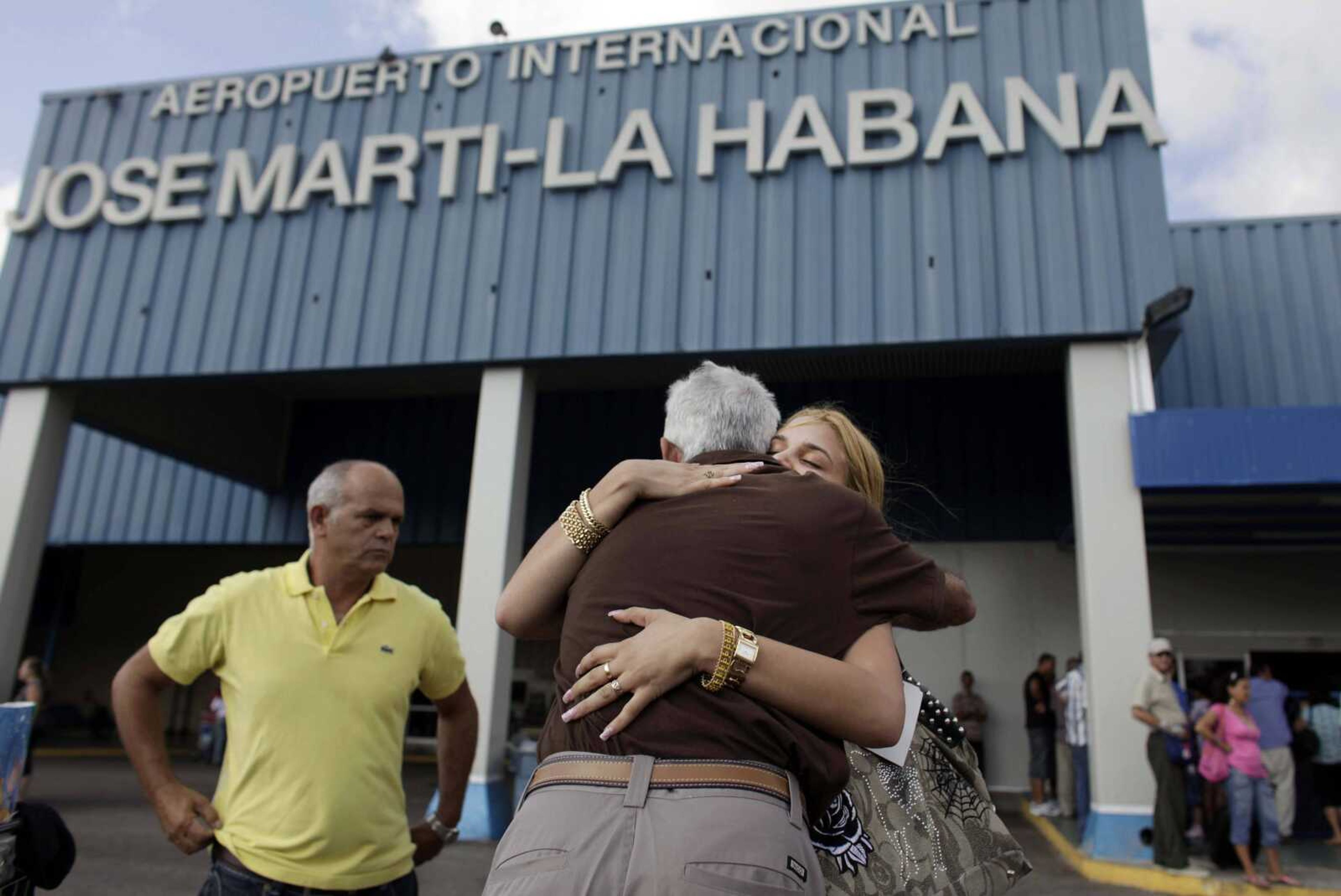 FILE - In this April 14, 2009 file photo, a woman is welcomed by relatives after arriving from the U.S. at the Jose Marti International Airport in Havana, Cuba. The Cuban government announced Tuesday, Oct. 16, 2012, that it will no longer require islanders to apply for an exit visa, eliminating a much-loathed bureaucratic procedure that has been a major impediment for many seeking to travel overseas. (AP Photo/Javier Galeano, File)