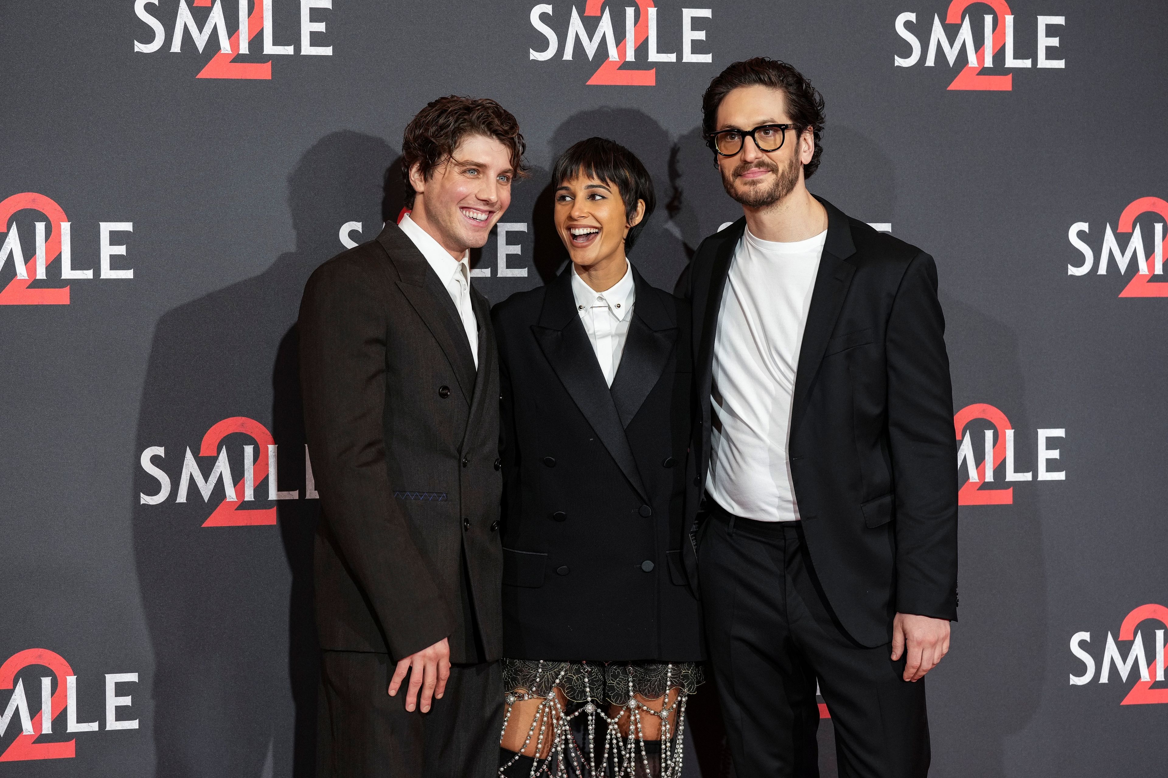 Lukas Gage, from left, Naomi Scott and director Parker Finn pose for photographers upon arrival at the premiere for the film 'Smile 2' on Tuesday, Oct. 8, 2024, in London. (Photo by Scott A Garfitt/Invision/AP)