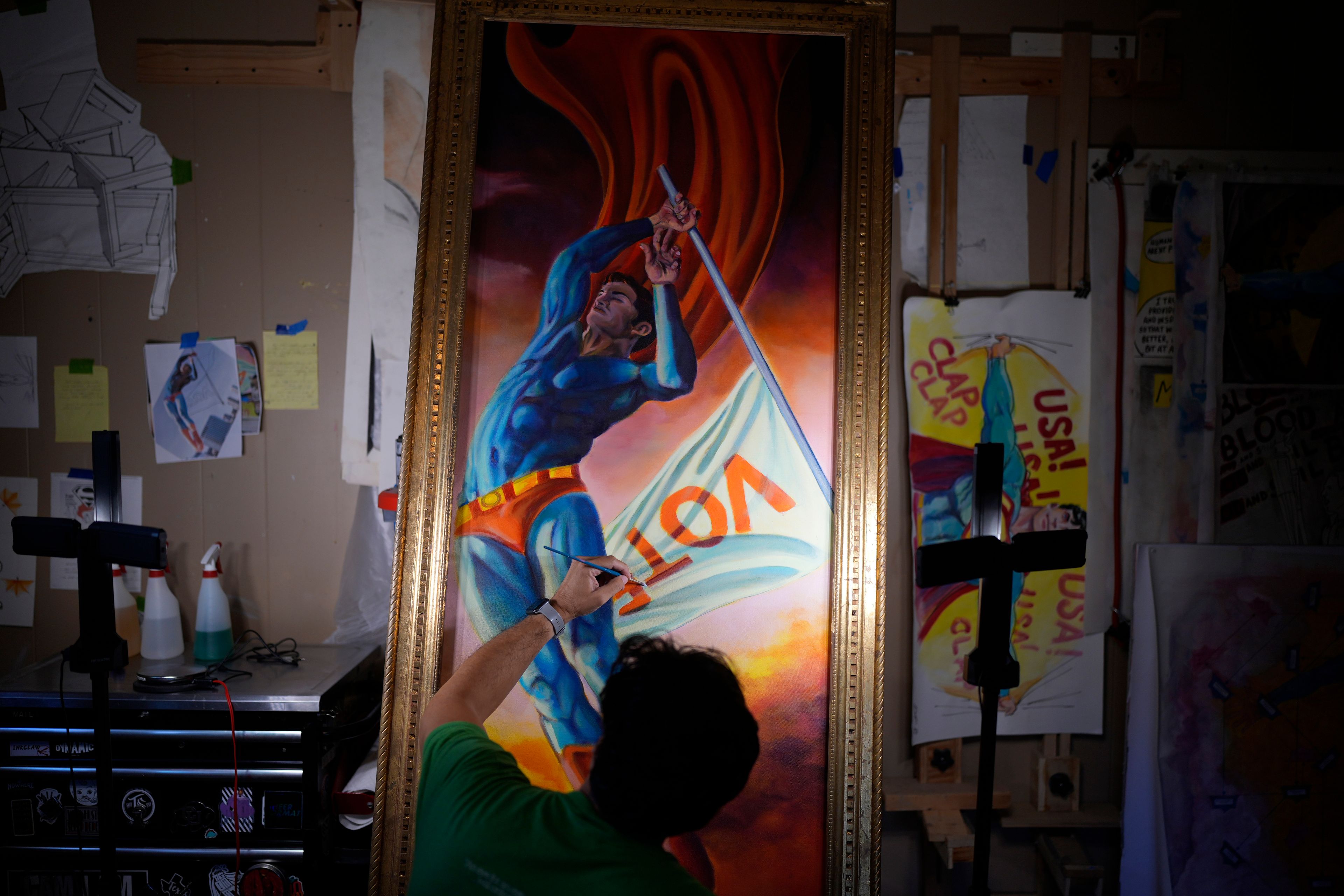 Artist David Alcantar works on an art piece for his "Superman Project" that in part encourages people to exercise their right to vote in San Antonio, Thursday, Sept. 19, 2024. (AP Photo/Eric Gay)