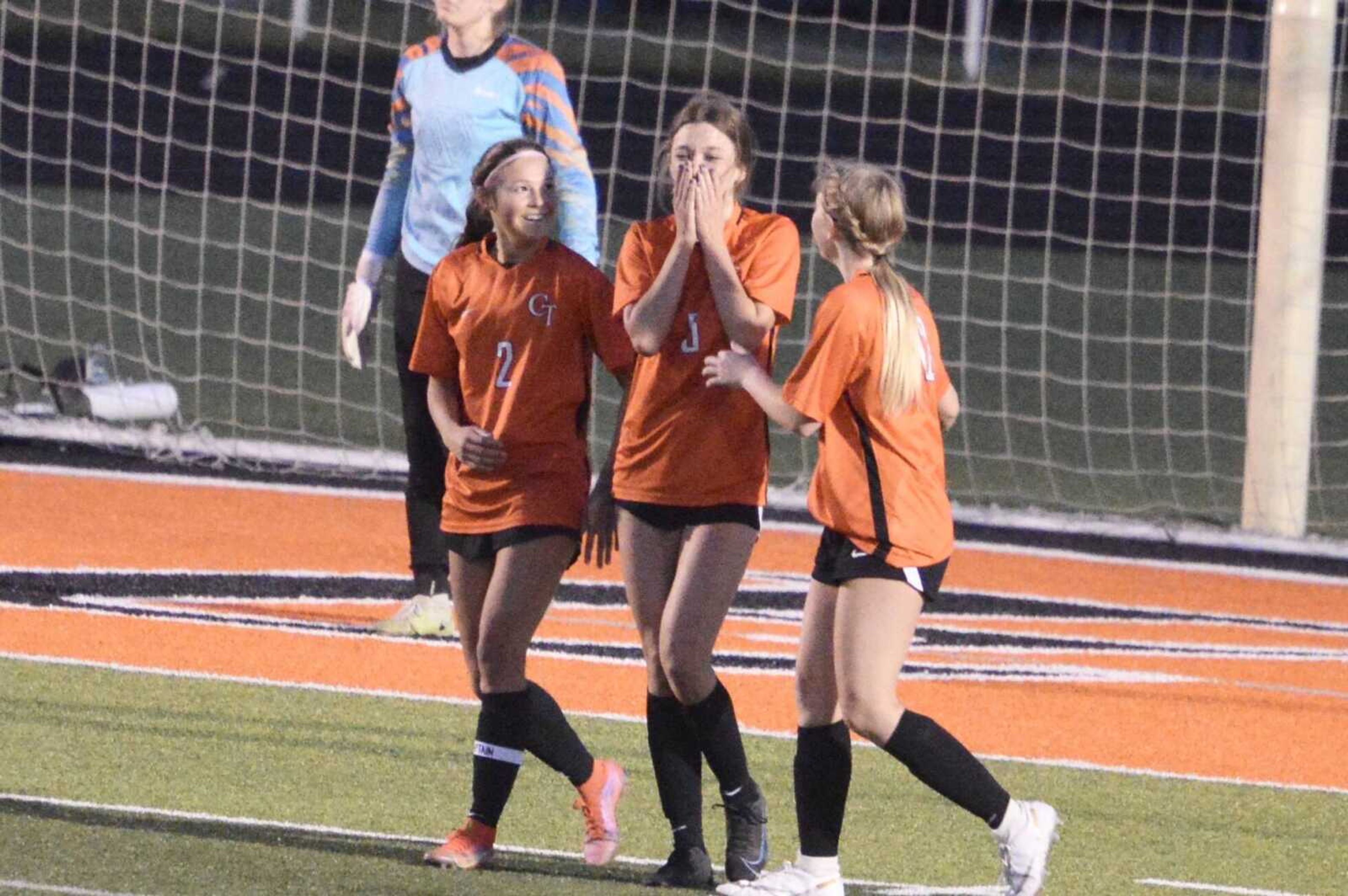 Cape Central's Tracie Helm (middle) celebrates with Averie Huff (left) and Tay Jennings (right) after scoring the opening goal in the Tigers' 3-0 win over the Poplar Bluff Mules at Cape Central High School. 