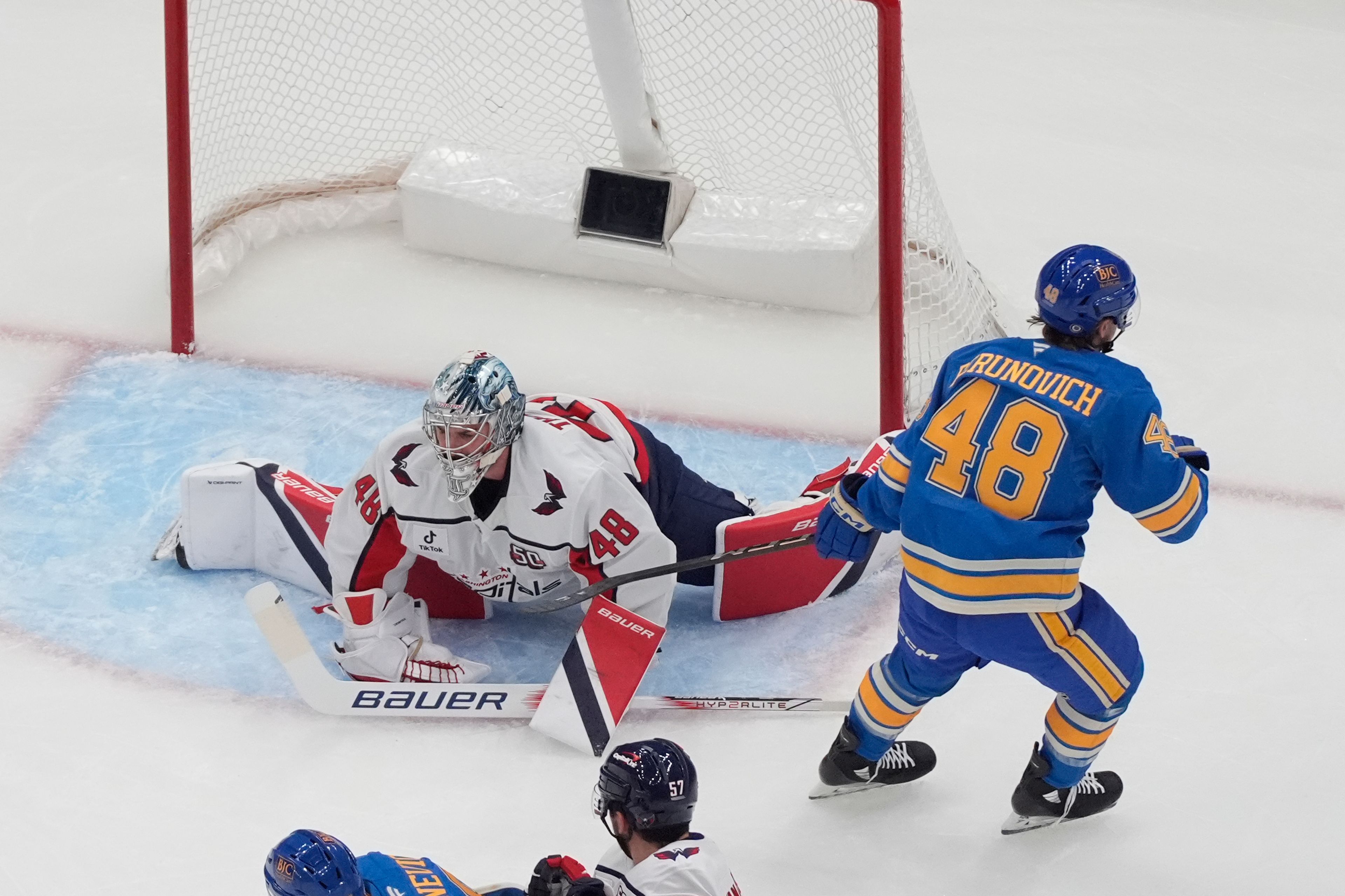 St. Louis Blues' Scott Perunovich (48) skates past Washington Capitals goaltender Logan Thompson (48) after scoring during the first period of an NHL hockey game Saturday, Nov. 9, 2024, in St. Louis. (AP Photo/Jeff Roberson)