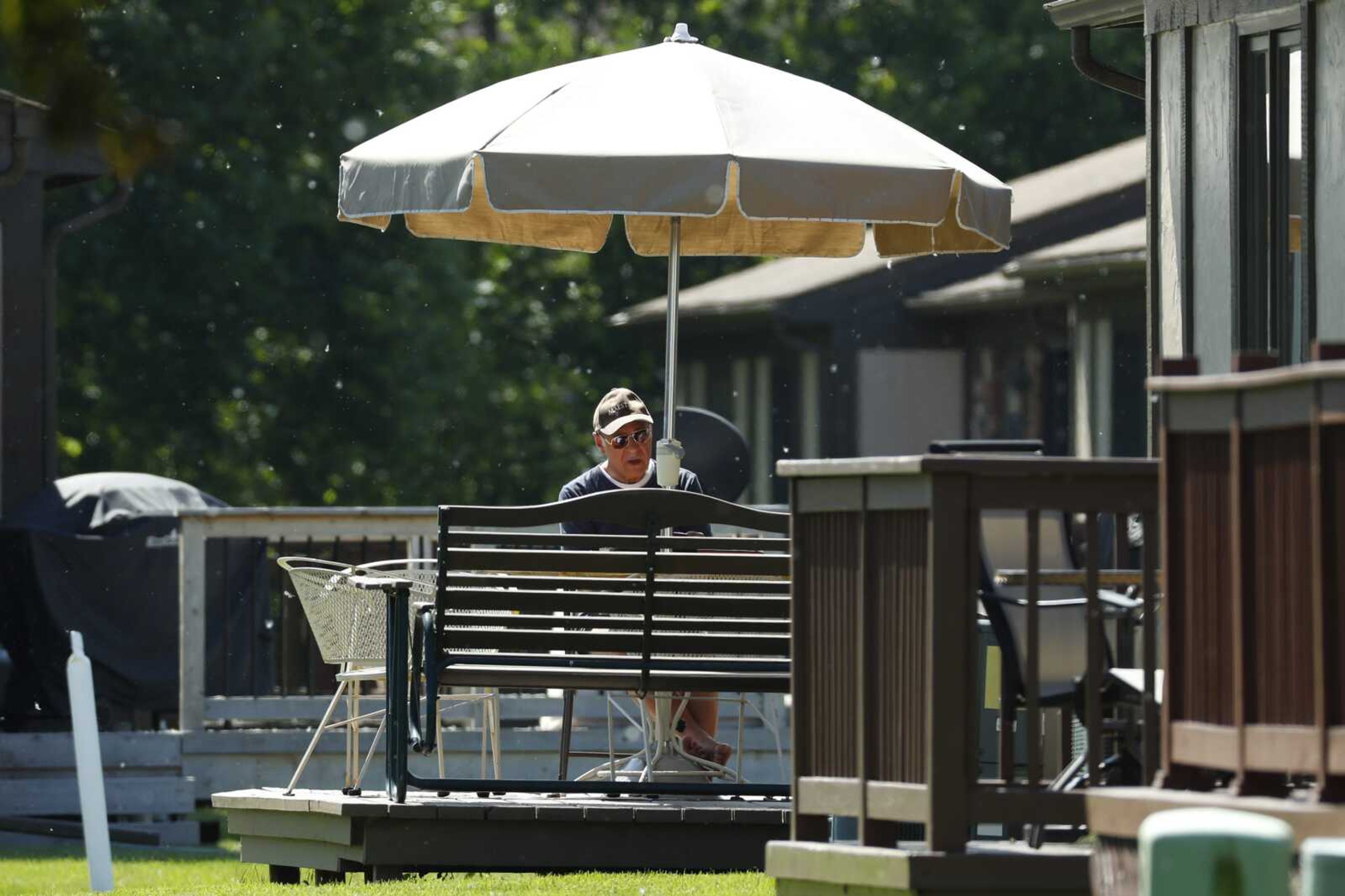 Father Eduard Perrone reads under an umbrella in Warren, Michigan. On July 7, the Roman Catholic Archdiocese of Detroit said it had removed Perrone, one of Opus Bono Sacerdotii's co-founders, from public ministry for an alleged sexual abuse episode.