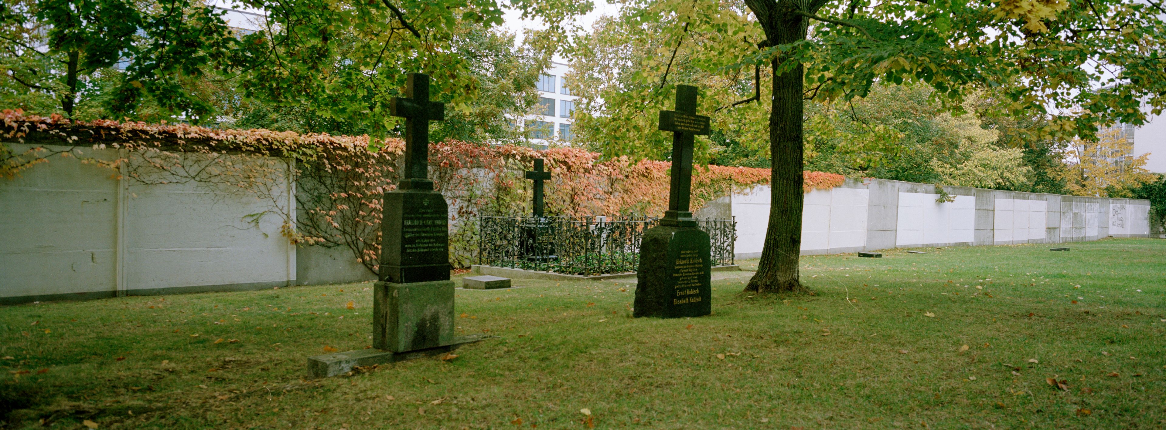 Crosses of a cemetery stand in front of remains of the Berlin Wall in central Berlin Wall in Berlin, Germany, Monday, Oct. 28, 2024. (AP Photo/Markus Schreiber)