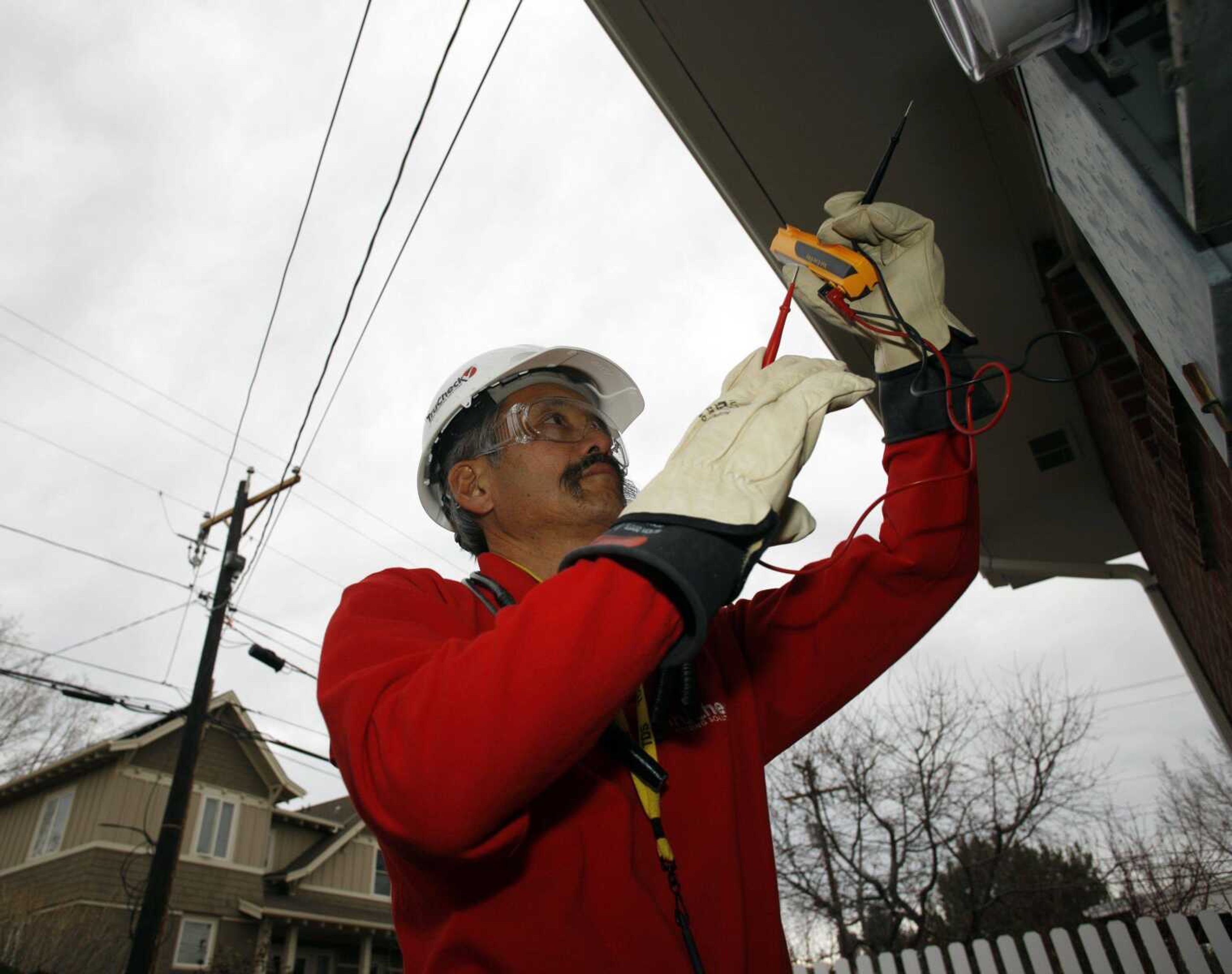 Gary Kawano installs a new meter outside a home Nov. 25 in Boulder, Colo., as part of the smart electrical grid system being put into place in the university city. (Associated Press, file)