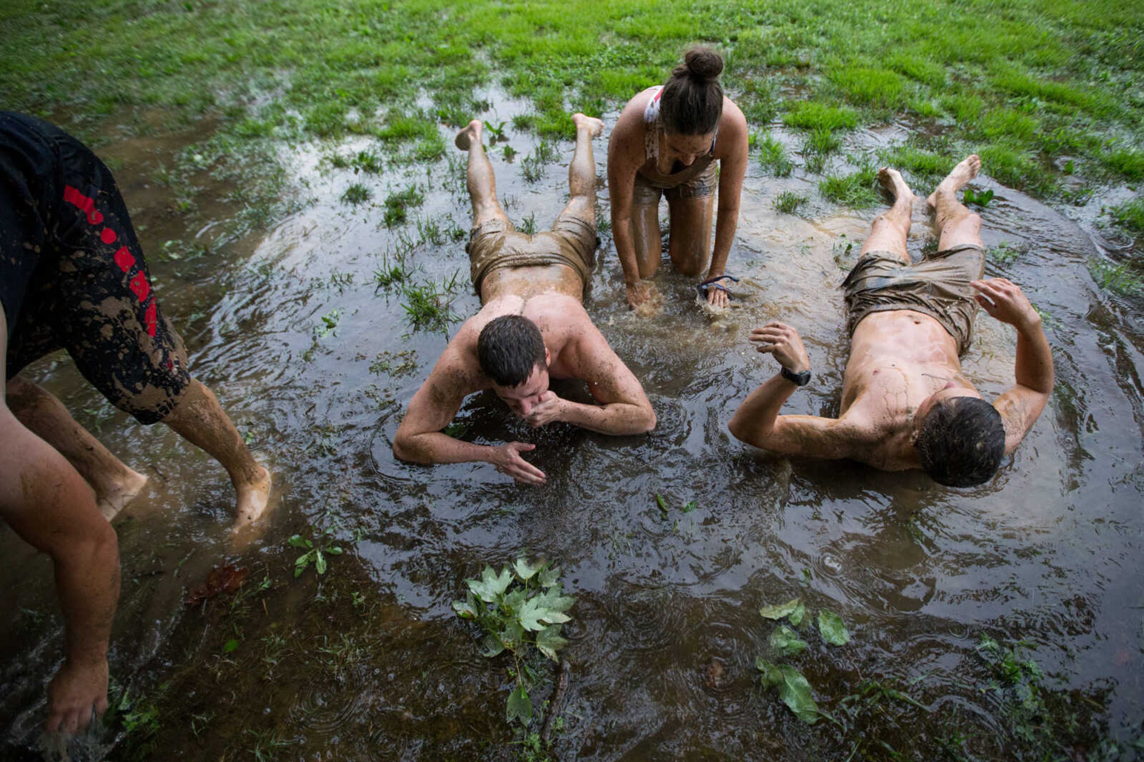 GLENN LANDBERG ~ glandberg@semissourian.com

Ethan Huber, left, Emily Thomas and Aaron Huber rinse off in a puddle after a game in the mud volleyball tournament during the Fourth of July celebration Monday, July 4, 2016 at Jackson City Park.