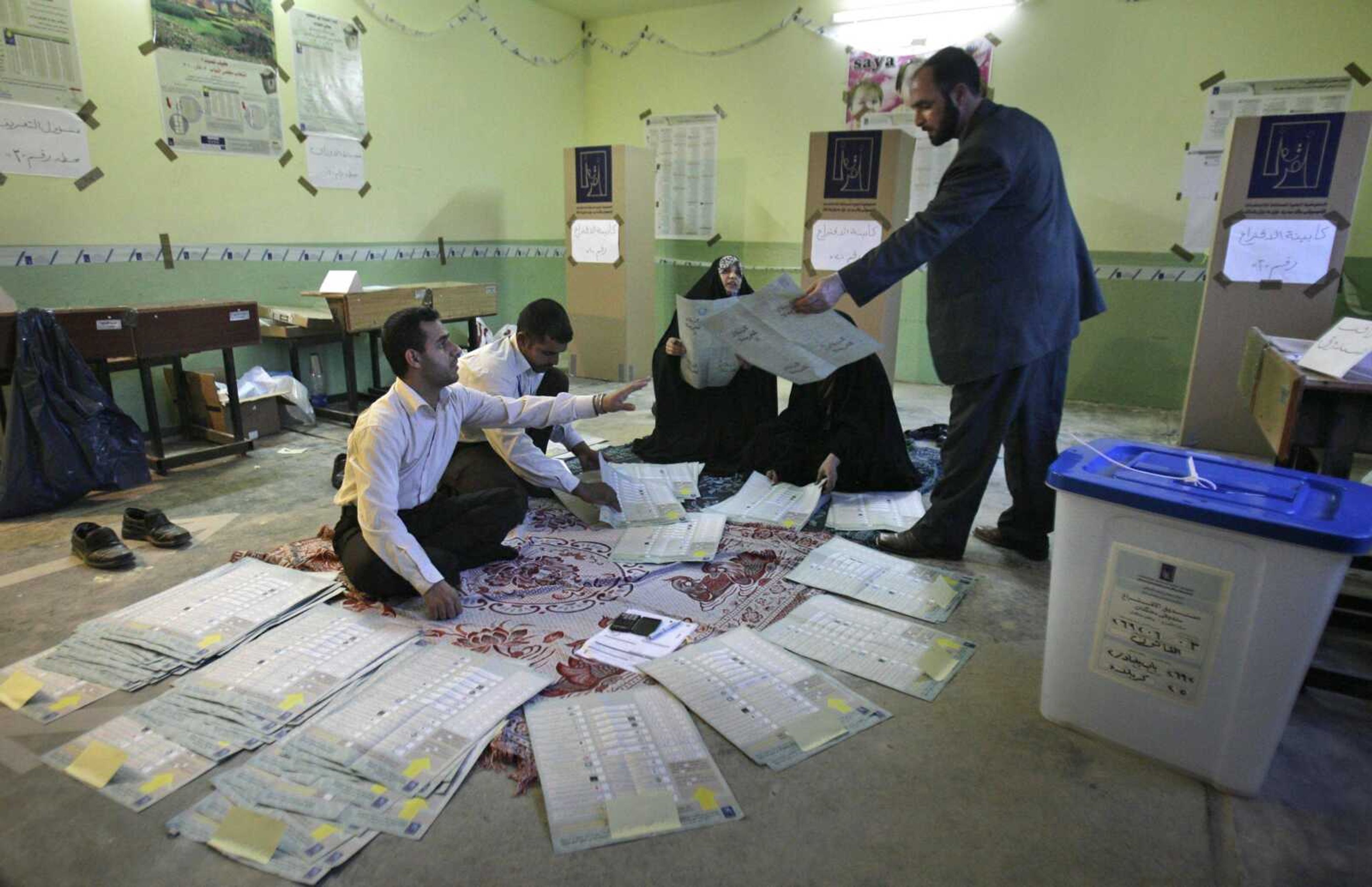 Electoral workers start the process of sorting and counting the ballot papers for the parliamentary elections Sunday at a polling station in Karbala, Iraq. Polls have closed in Iraq's parliamentary elections after a spate of attacks that marred the vote and left 36 people dead, despite tight security. (Ahmed al-Hussainey ~ Associated Press)