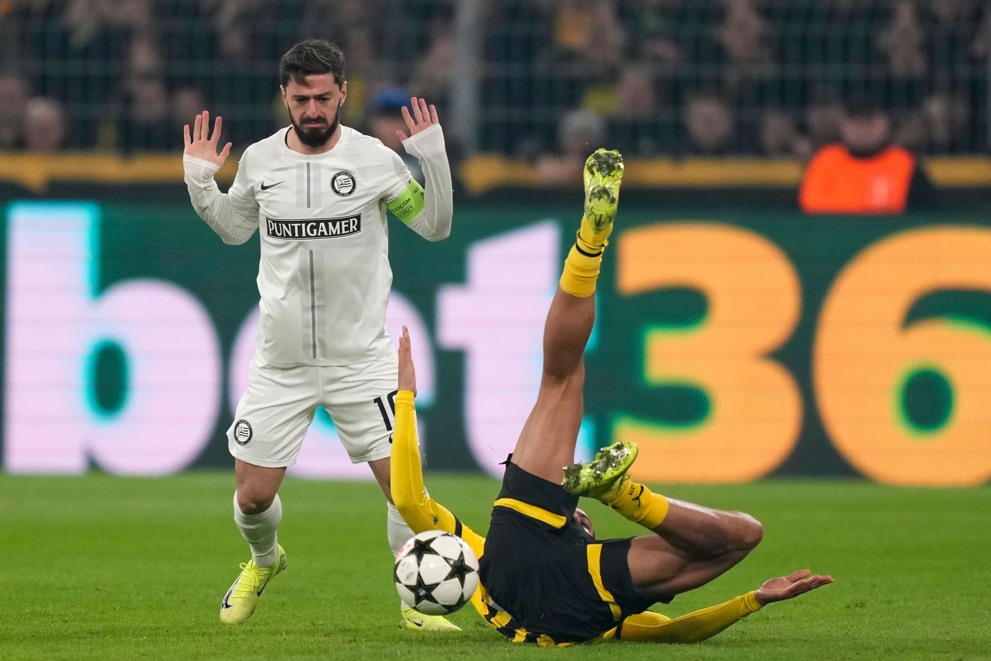 Sturm's Otar Kiteishvili, left, challenges Dortmund's Felix Nmecha during to the Champions League opening phase soccer match between Borussia Dortmund and Sturm Graz in Dortmund, Germany, Tuesday, Nov. 5, 2024. (AP Photo/Martin Meissner)