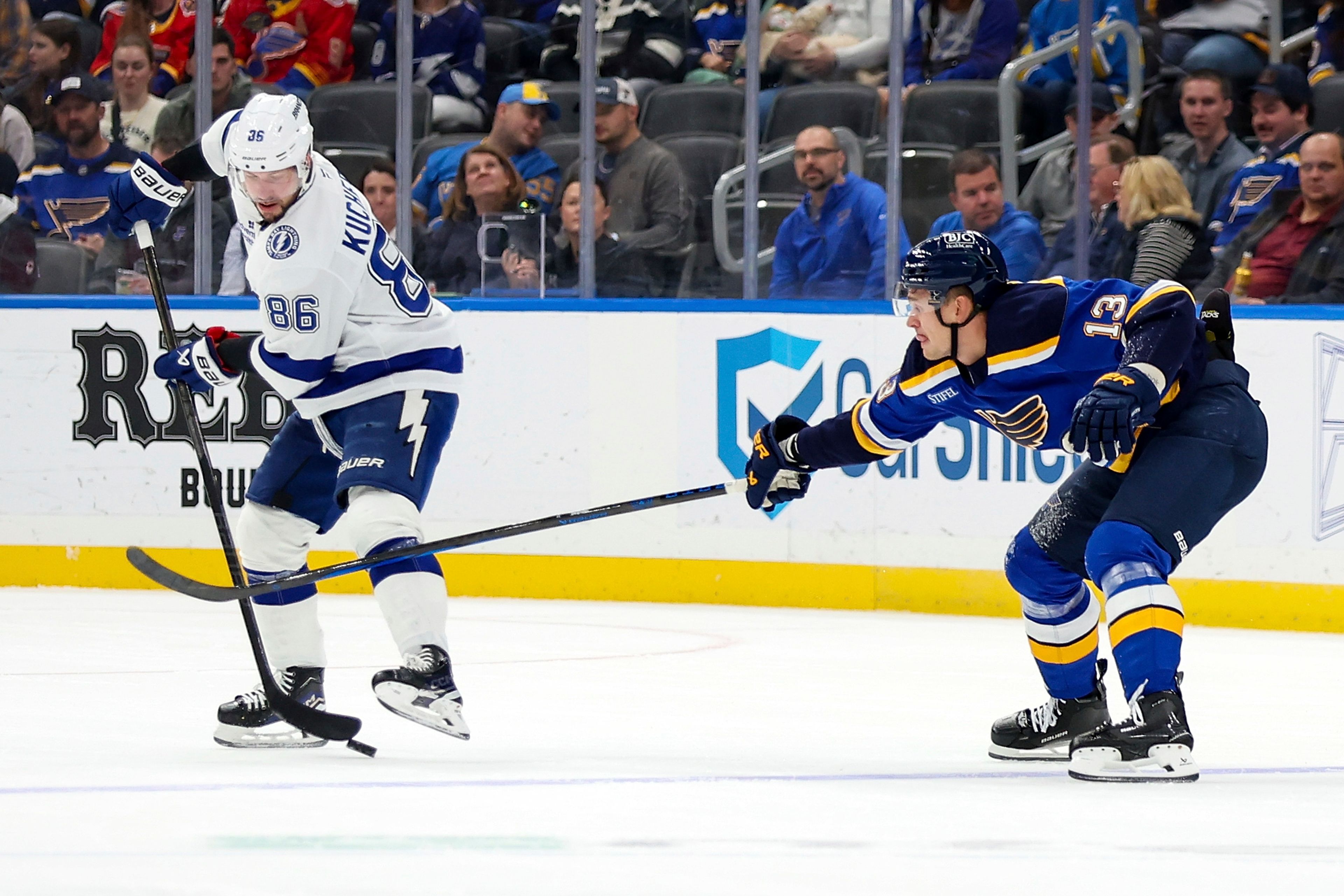 Tampa Bay Lightning's Nikita Kucherov (86) handles the puck as St. Louis Blues' Alexey Toropchenko (13) defends during the first period of an NHL hockey game Tuesday, Nov. 5, 2024, in St. Louis. (AP Photo/Scott Kane)