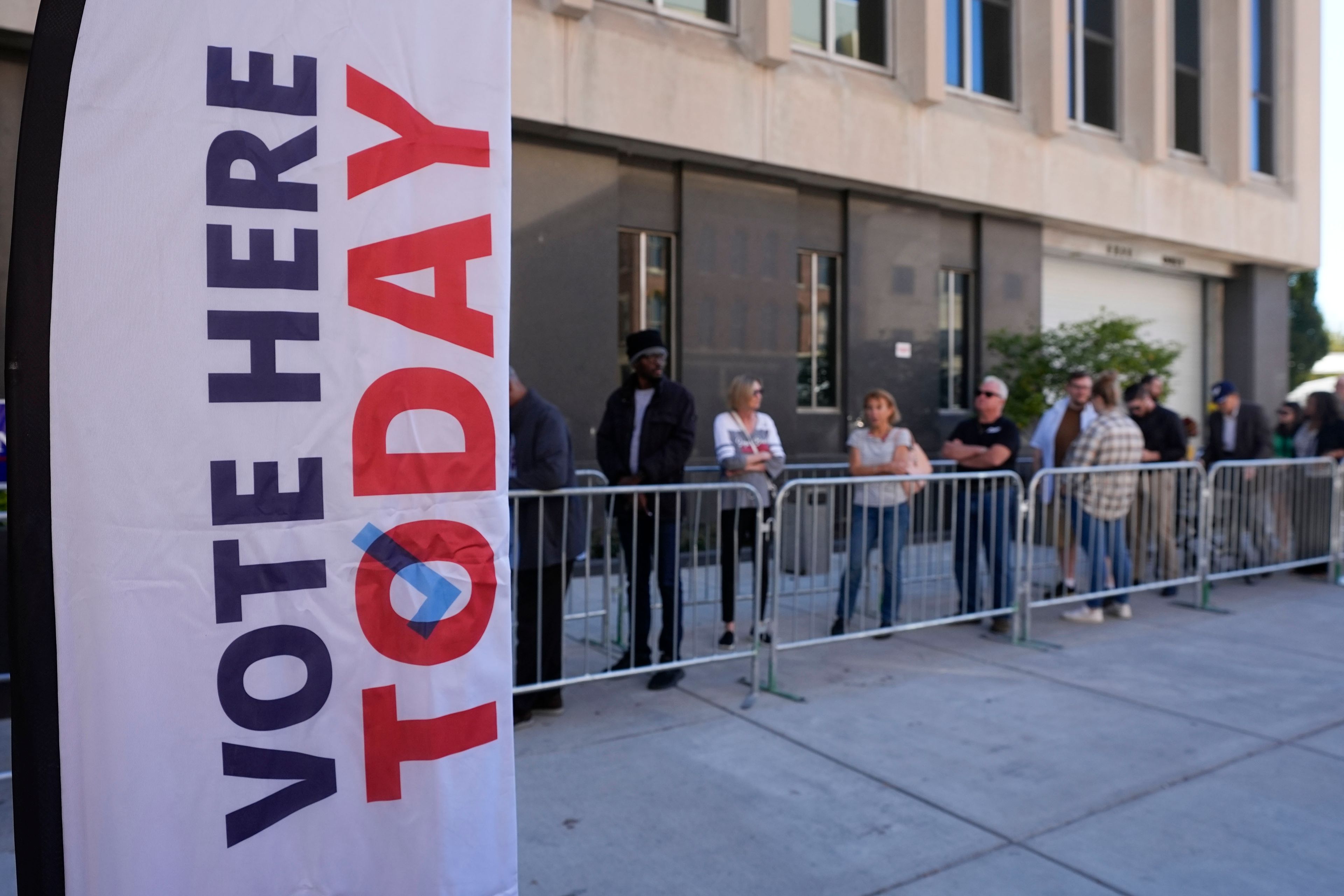 Voters line up outside of the City-County Building for in-person absentee voting, Tuesday, Oct. 8, 2024, in Indianapolis. (AP Photo/Darron Cummings)