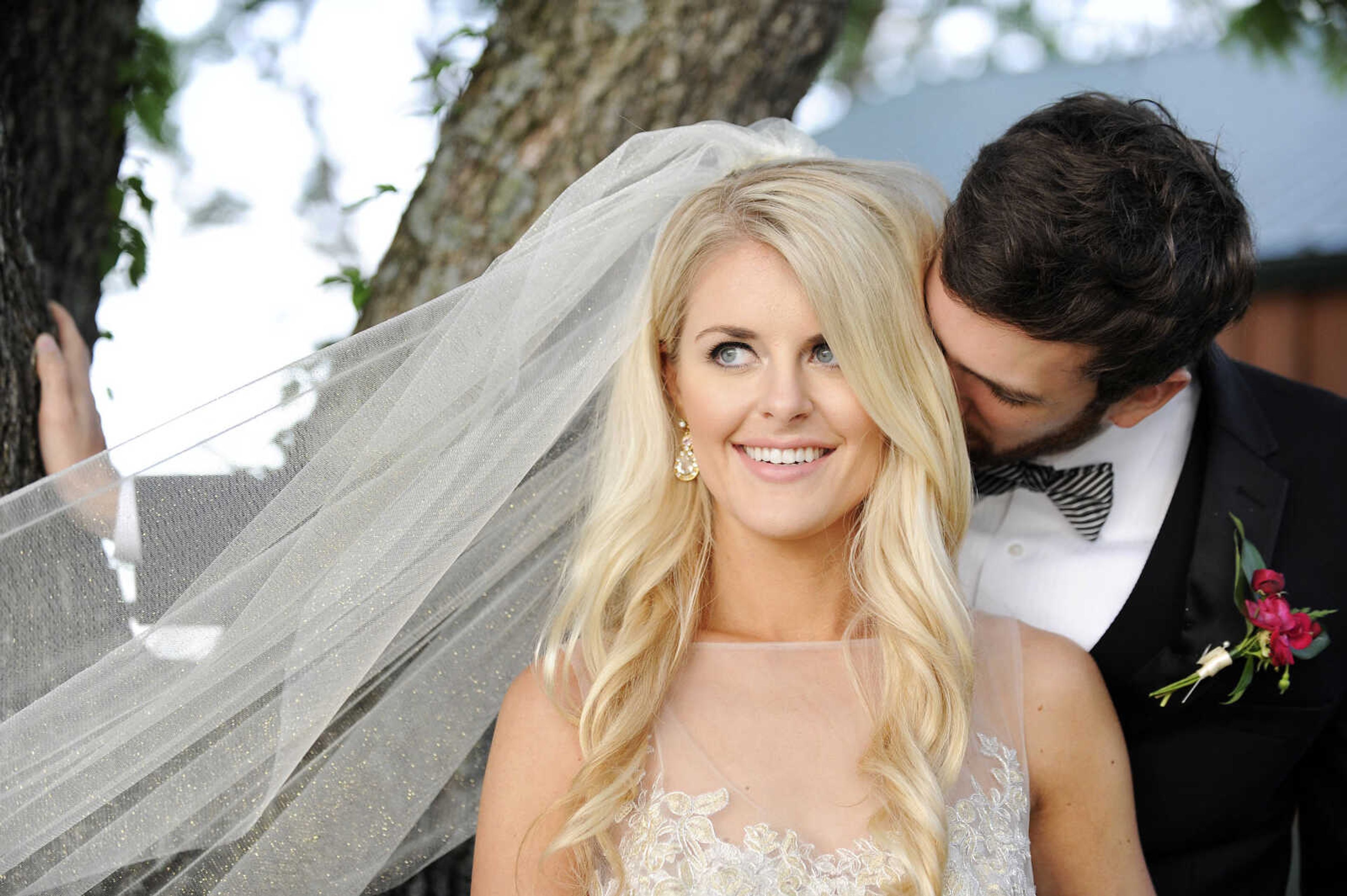 On Paige: This Tara Keely ballgown in ivory gold has an illusion scoop neckline, a V-back with cascading lace detail and an asymmetrical tiered skirt. The gown is accessorized with a glitzy gold belt and sparkle illusion cathedral-length veil, both by Lindsay Marie. Dress and accessories available at Magnolias Bridal Boutique in Cape Girardeau.

On Spencer: Manhattan slim fit tuxedo with solid black vest and black and white striped bow tie. Provided by Kim's Formal Wear and available at Garber's Men's Wear in Cape Girardeau.