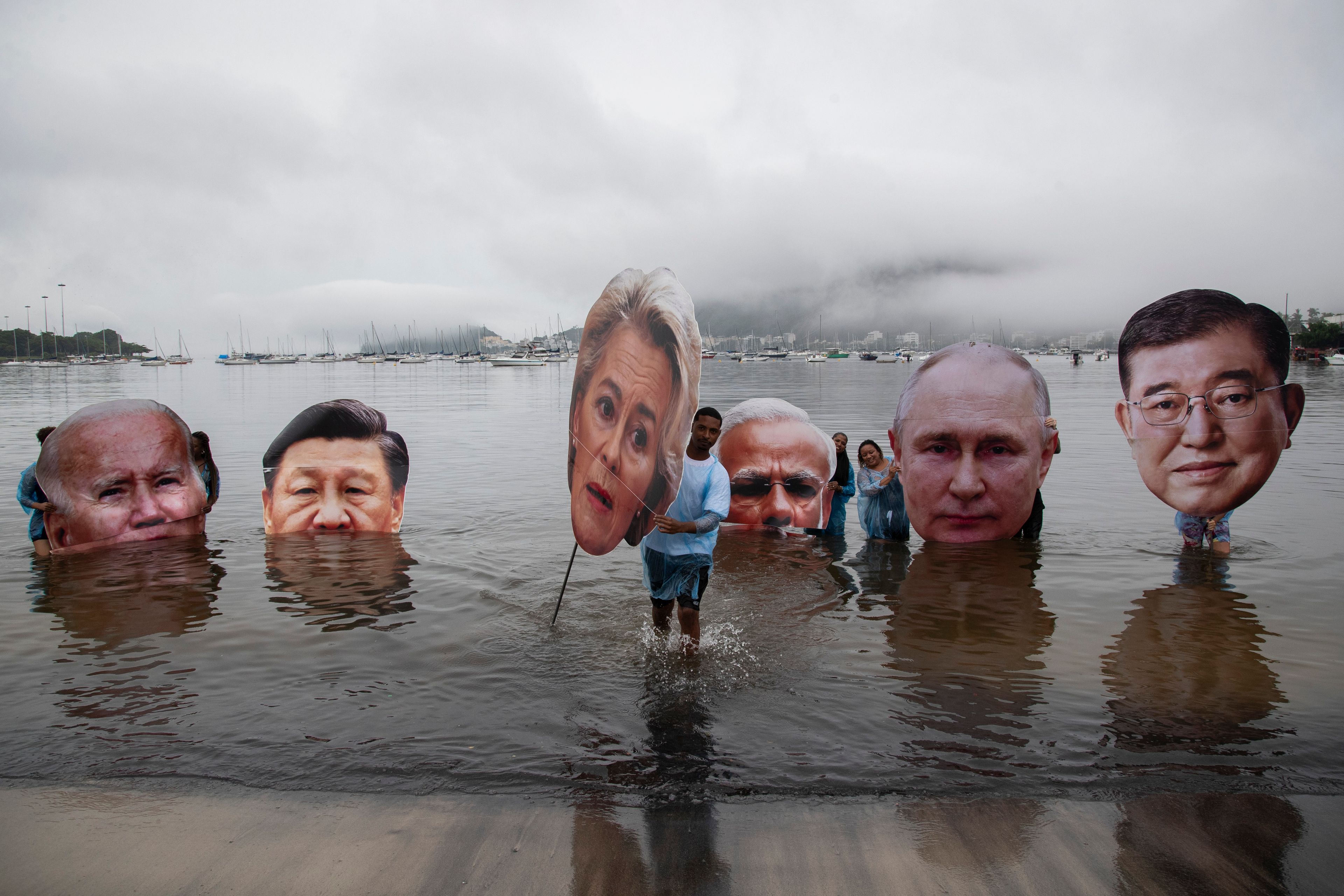 Activists from a Brazilian Indigenous movement hold cutouts of President Joe Biden, from left, Chinese President Xi Jinping, President of the European Commission Ursula von der Leyen, Indian Prime Minister Narendra Modi, Russian President Vladimir Putin, and Japan's Prime Minister Shigeru Ishiba, during a protest aimed at drawing the attention on the global climate crisis to leaders attending the upcoming G20 Summit, at Botafogo Beach in Rio de Janeiro, Nov. 16, 2024. (AP Photo/Bruna Prado)