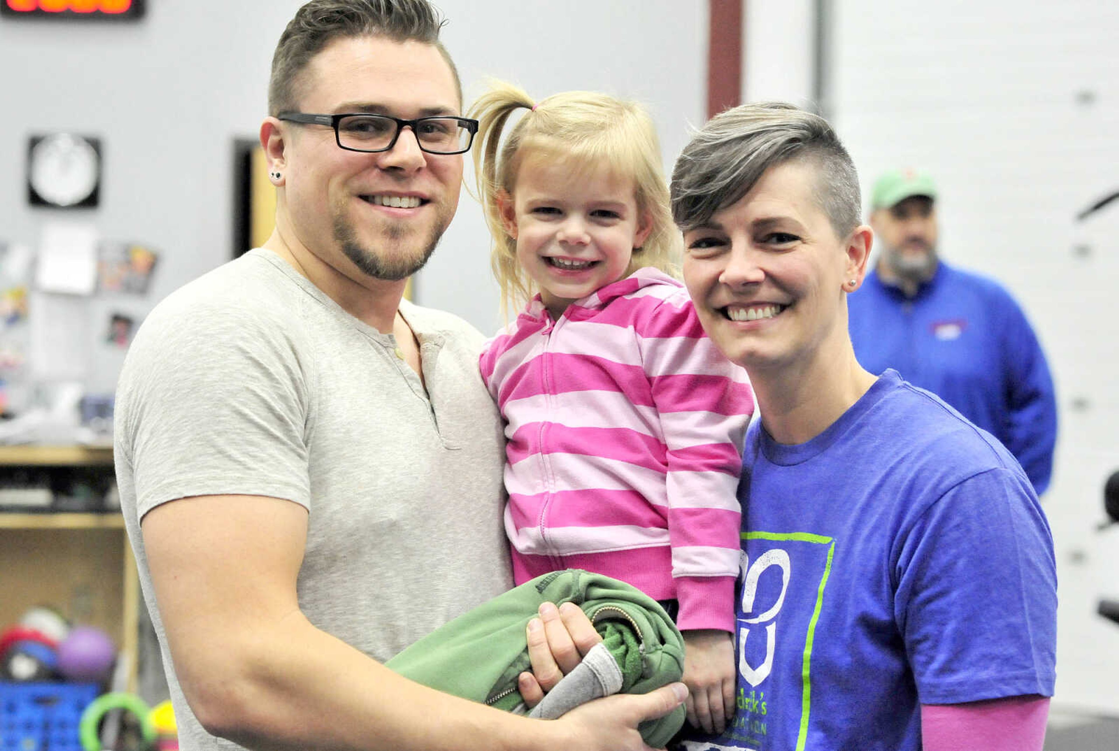 David and Andrea Allstun pose for a photo with their daughter, Zola, 3, on Saturday, March 4, 2017, during the St. Baldrick's Foundation fundraiser at Old Orchard CrossFit in Jackson.