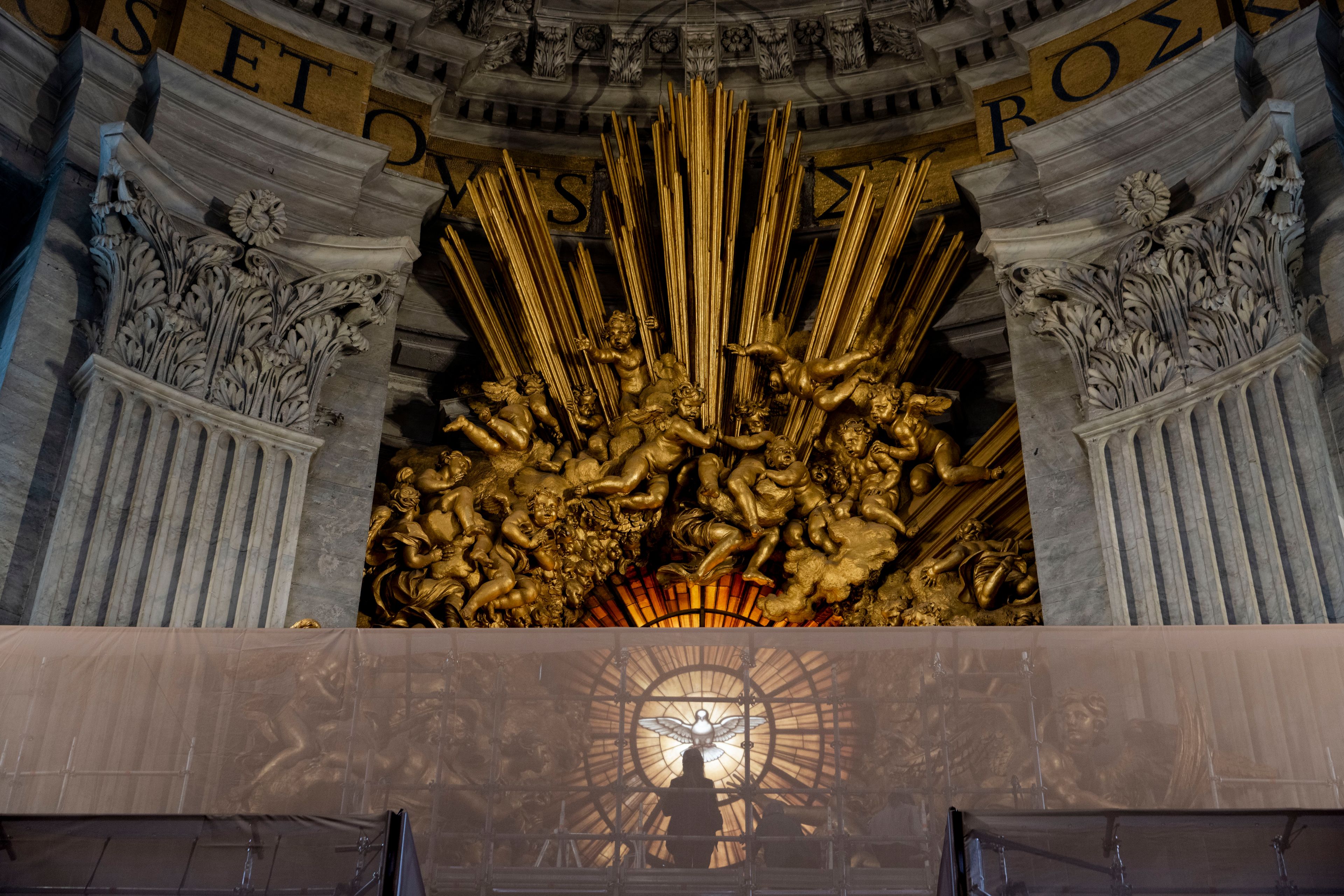 Journalists look, Tuesday, Oct. 8, 2024, at the restoration works of the Cathedra of St. Peter's inside St. Peter's Basilica at The Vatican. Bernini's monumental bronze canopy has been under restoration too since February while expert conservators worked meticulously on its intricate surface. (AP Photo/Domenico Stinellis)