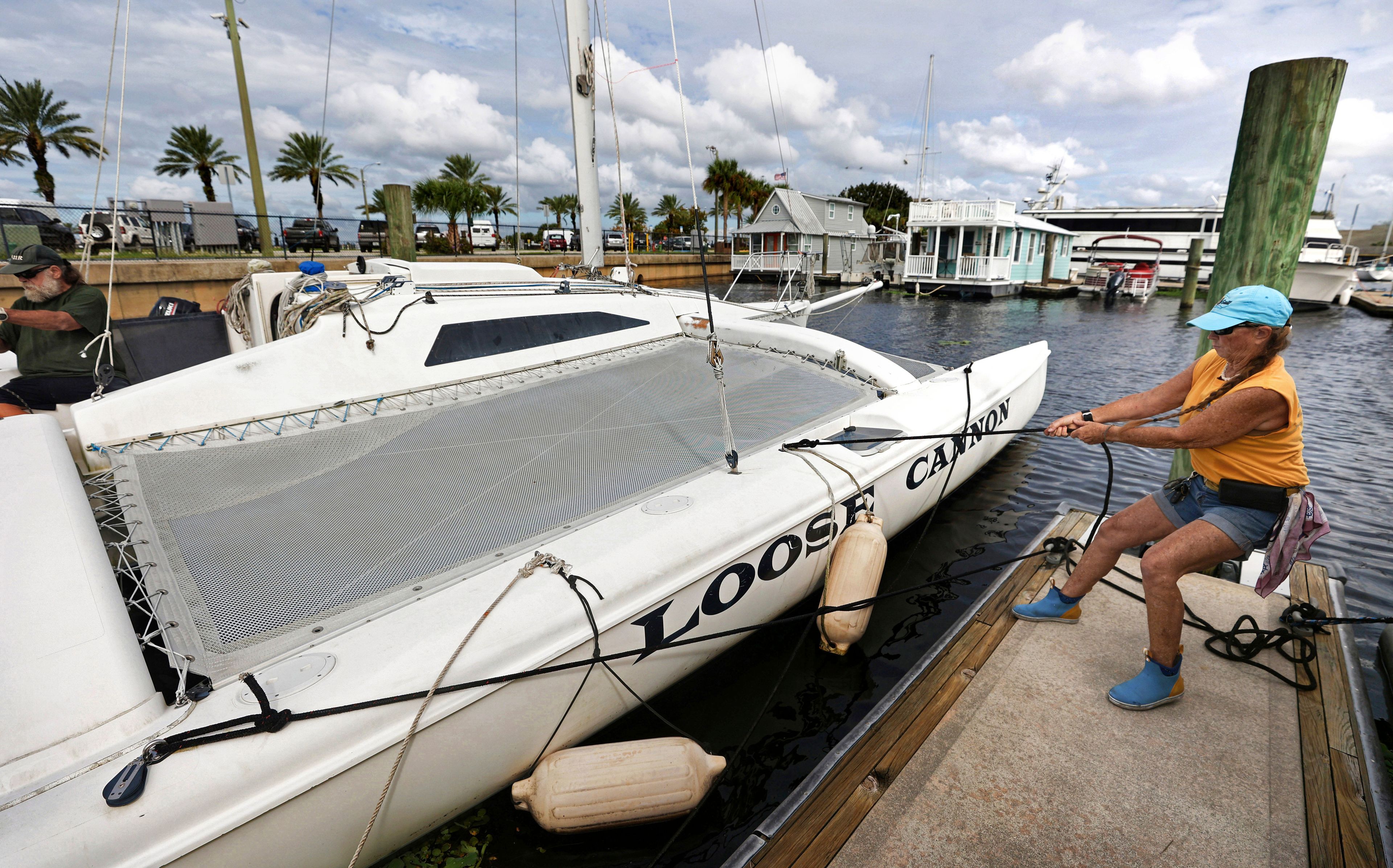 Captain D.J. McCabe helps batten down a catamaran at the Downtown Sanford Marina on Lake Monroe in Sanford, Fla., Tuesday, Oct. 8, 2024, in preparation for the impact of Hurricane Milton. (Joe Burbank/Orlando Sentinel via AP)