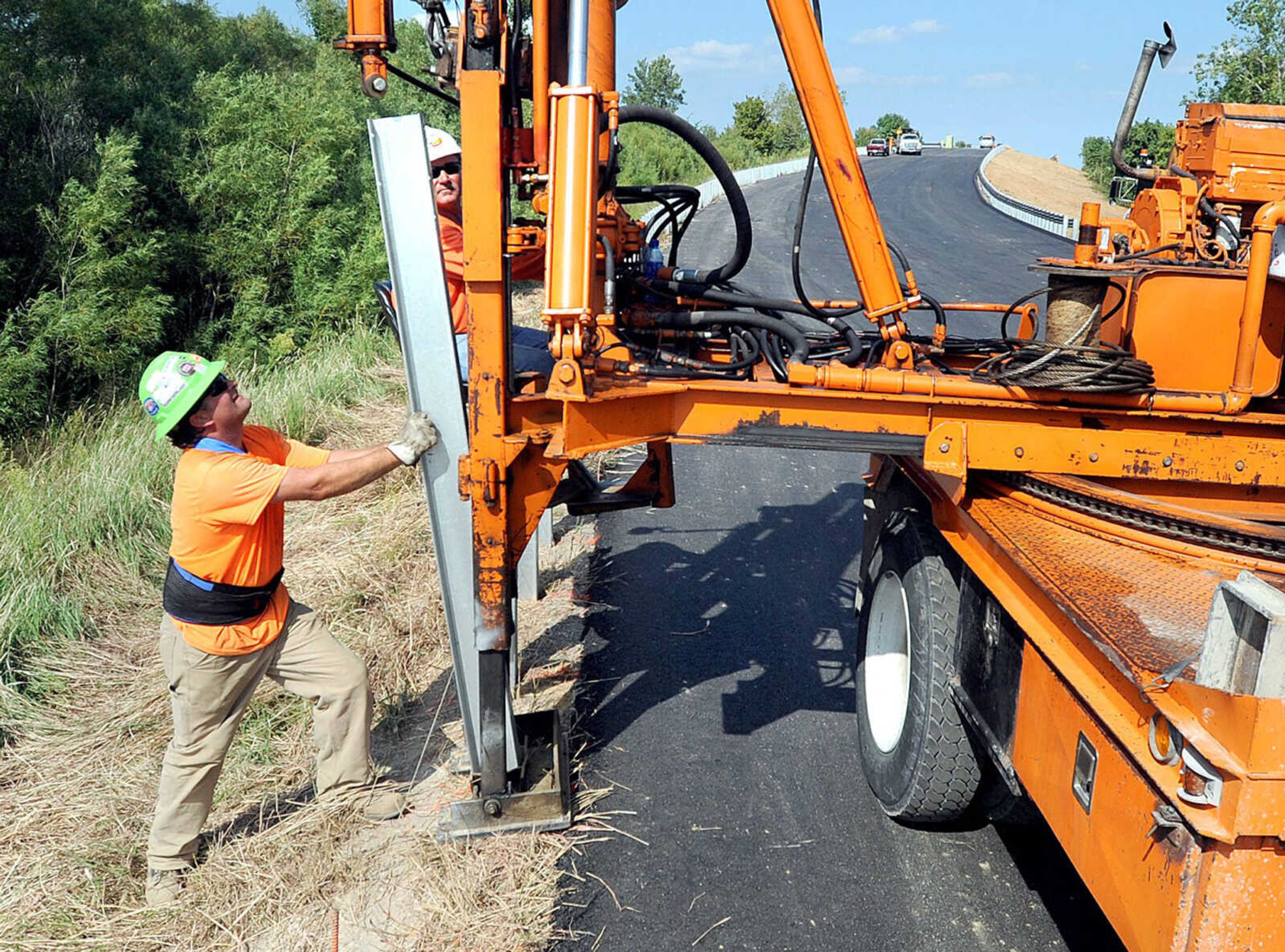 Rich Thompson, left, and Kevin Lowe with Collins & Hermann, Inc. install some of the nearly 5000 feet of guardrail along the reconstructed Route M overpass, Wednesday, Aug. 28, 2013 in Rockview, Mo. A train collision partially collapsed the overpass in May. The Route M overpass is set to open Friday at noon. (Laura Simon)