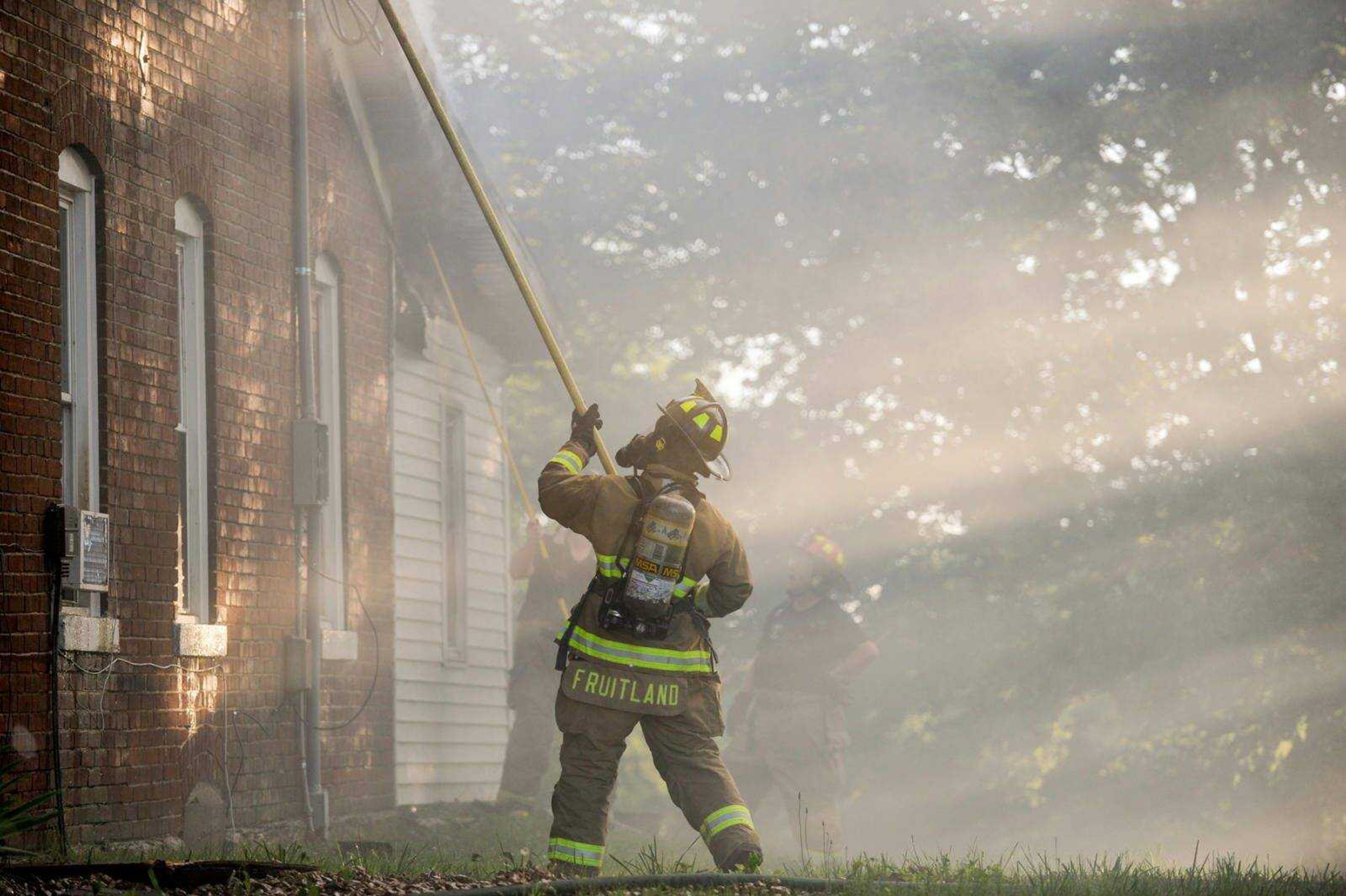 A Fruitland firefighter works to extinguish a house fire that broke out at 257 Church St. in Pocahontas on June 9.