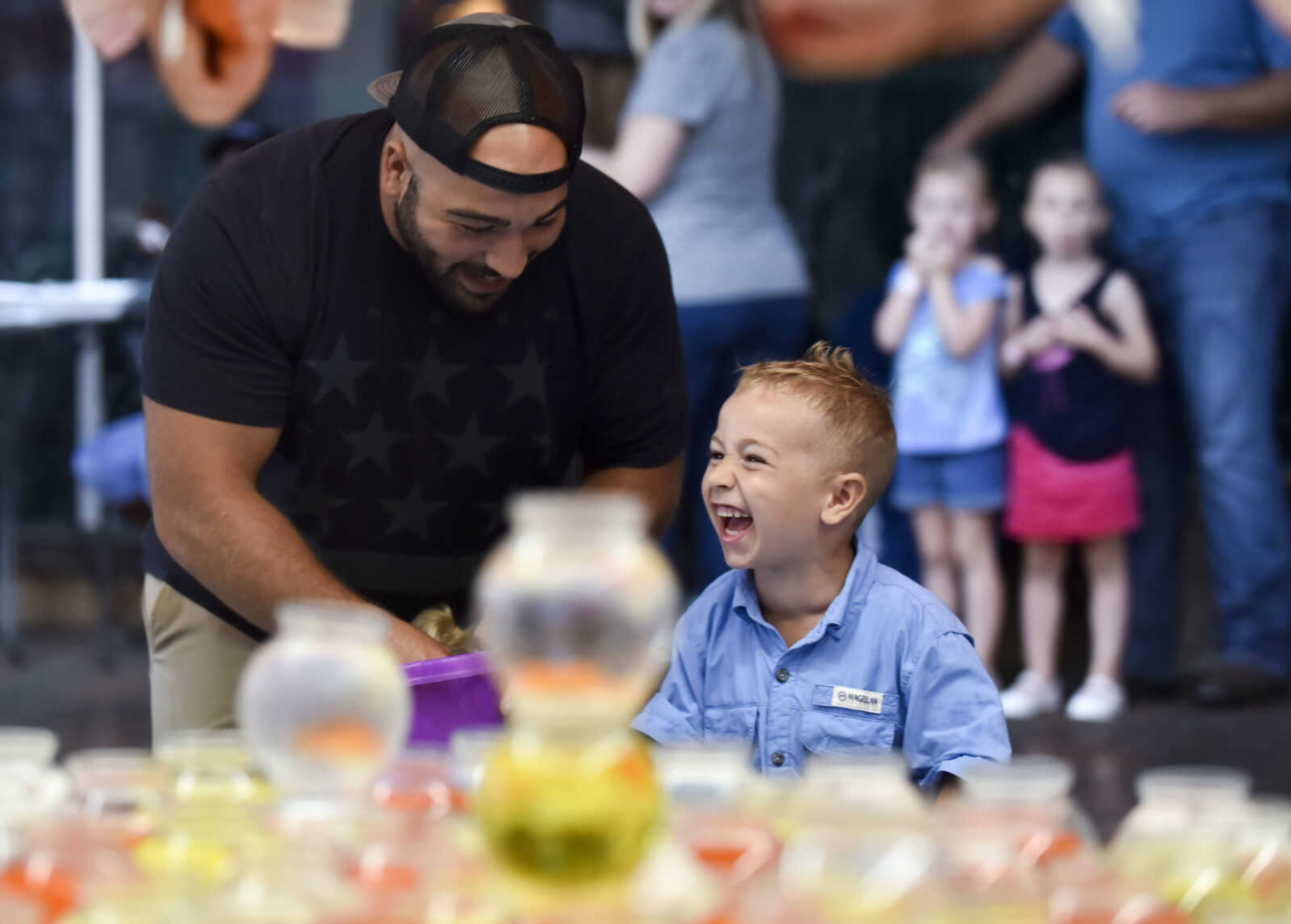 Matt Rehan, left, celebrates with his son Jameson, 4, after winning a goldfish at a booth Thursday, July 27, 2018 during Jackson Homecomers.