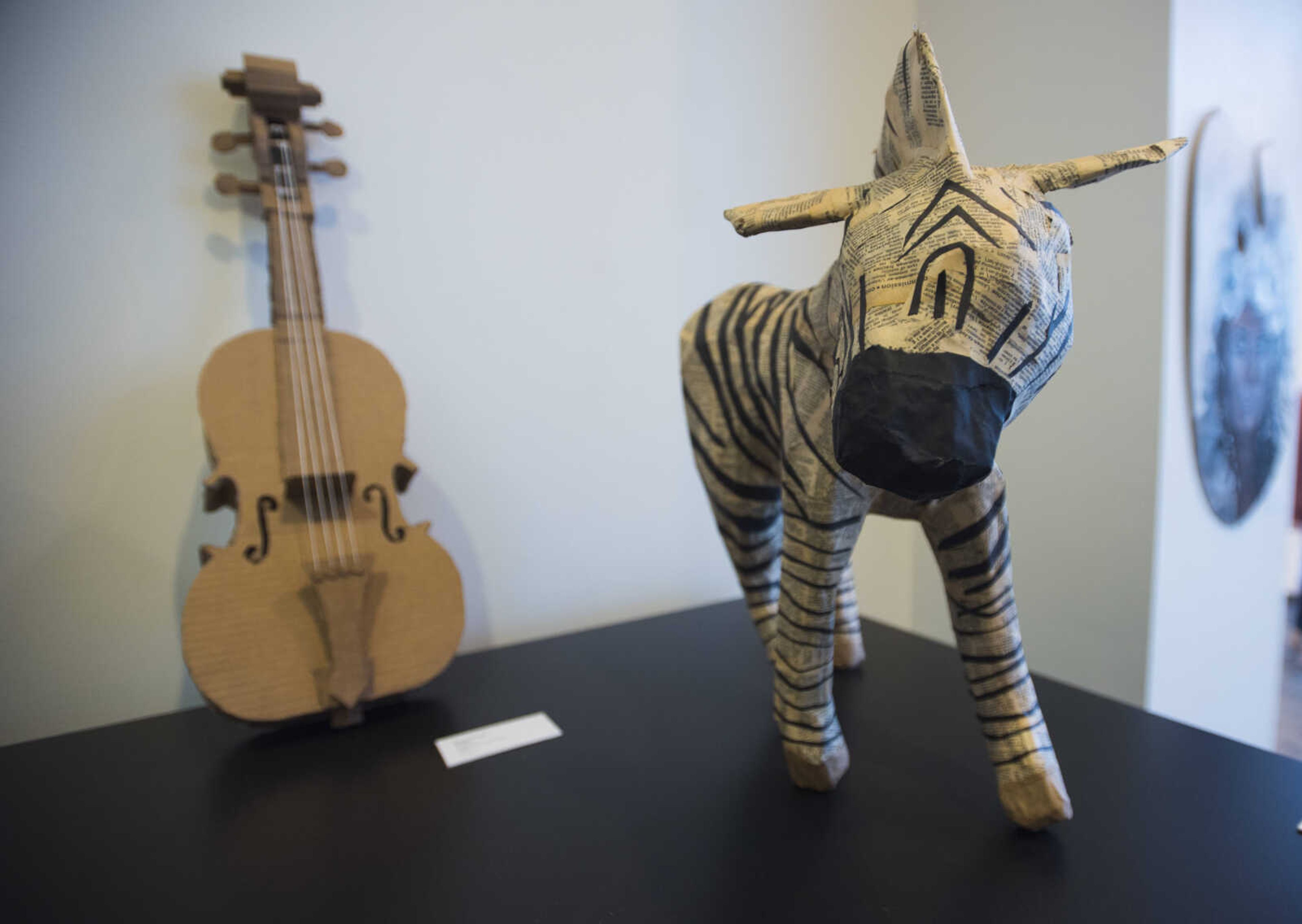 Kenzie Koepp of Kelly's sculpture "Violin" sits beside Lindsey Allen of Jackson's sculpture "Zebra" during a high school art exhibition Sunday, Feb. 18, 2018, at Crisp Museum in Cape Girardeau.