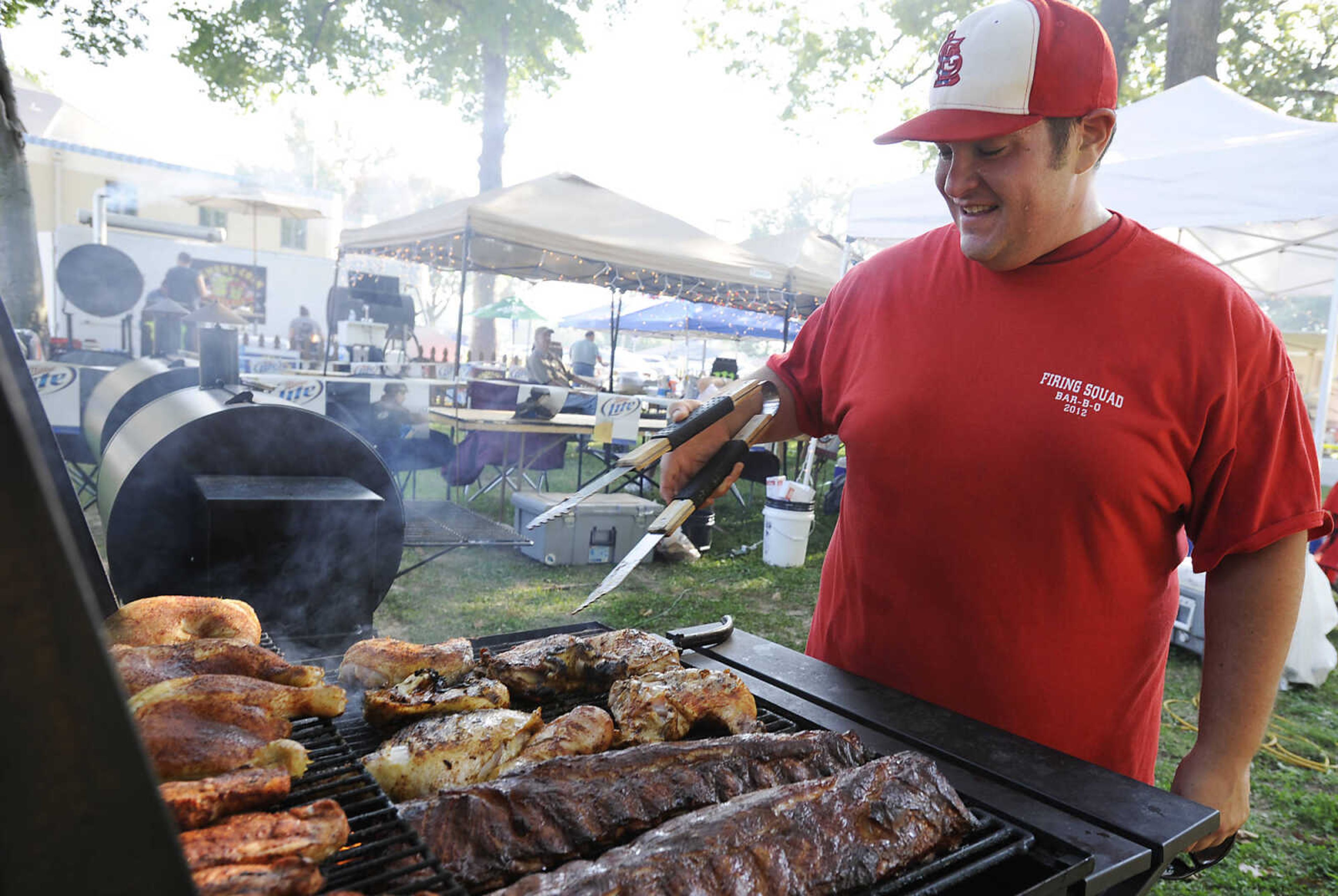 Gabriel Kinder tends one of the Firing Squad Bar-B-Q team's smokers at the 21st annual Cape BBQ Fest Friday, Aug. 23, at Arena Park in Cape Girardeau. Sponsored by the Cape Girardeau Jaycees there are fifty-seven teams competing in the event which is sanctioned by the Kansas City Barbecue Society.