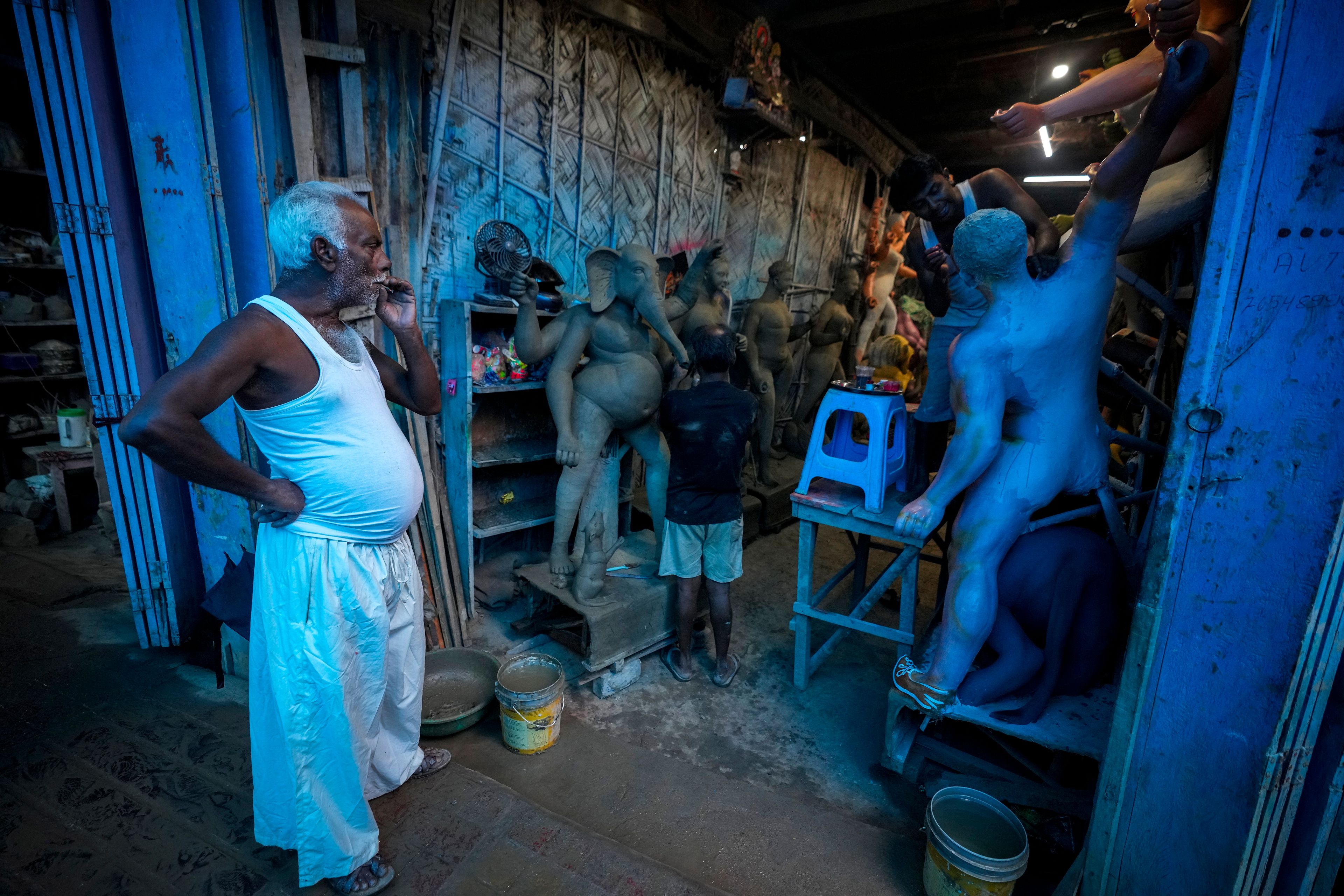 Ratan Paul, 70, stands at the entrance to his workshop making mud idols of the Hindu goddess Durga and other deities, during the Durga Puja festival in Guwahati, India, Friday, Oct. 4, 2024. (AP Photo/Anupam Nath)