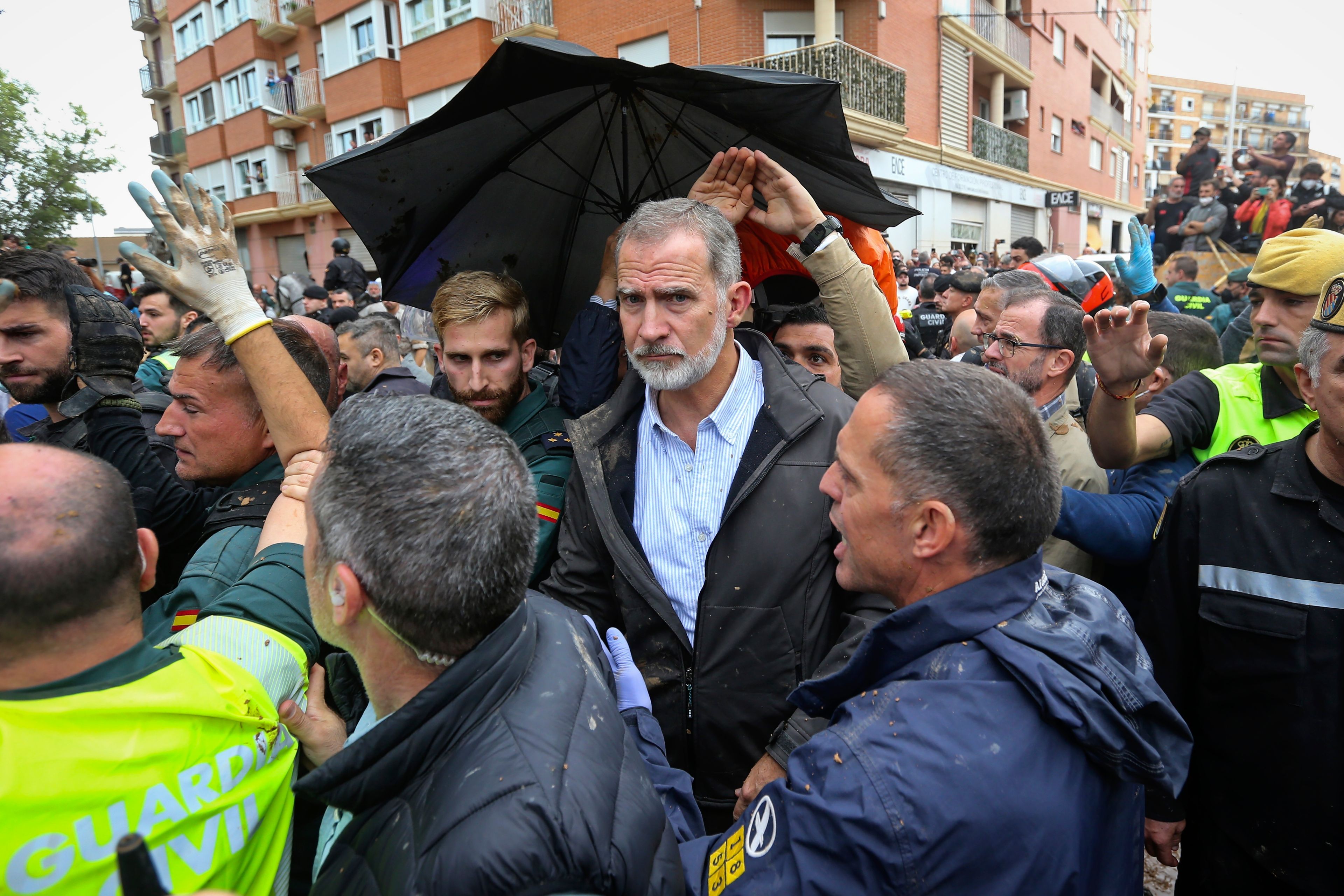 Spain's King Felipe VI is protected after a crowd of angry survivors of Spain's floods have tossed mud and shouted insults at the King and government officials when they made their first visit to one of the hardest hit towns after floods in Paiporta near Valencia, Spain, Sunday, Nov. 3, 2024. (AP Photo/Hugo Torres)