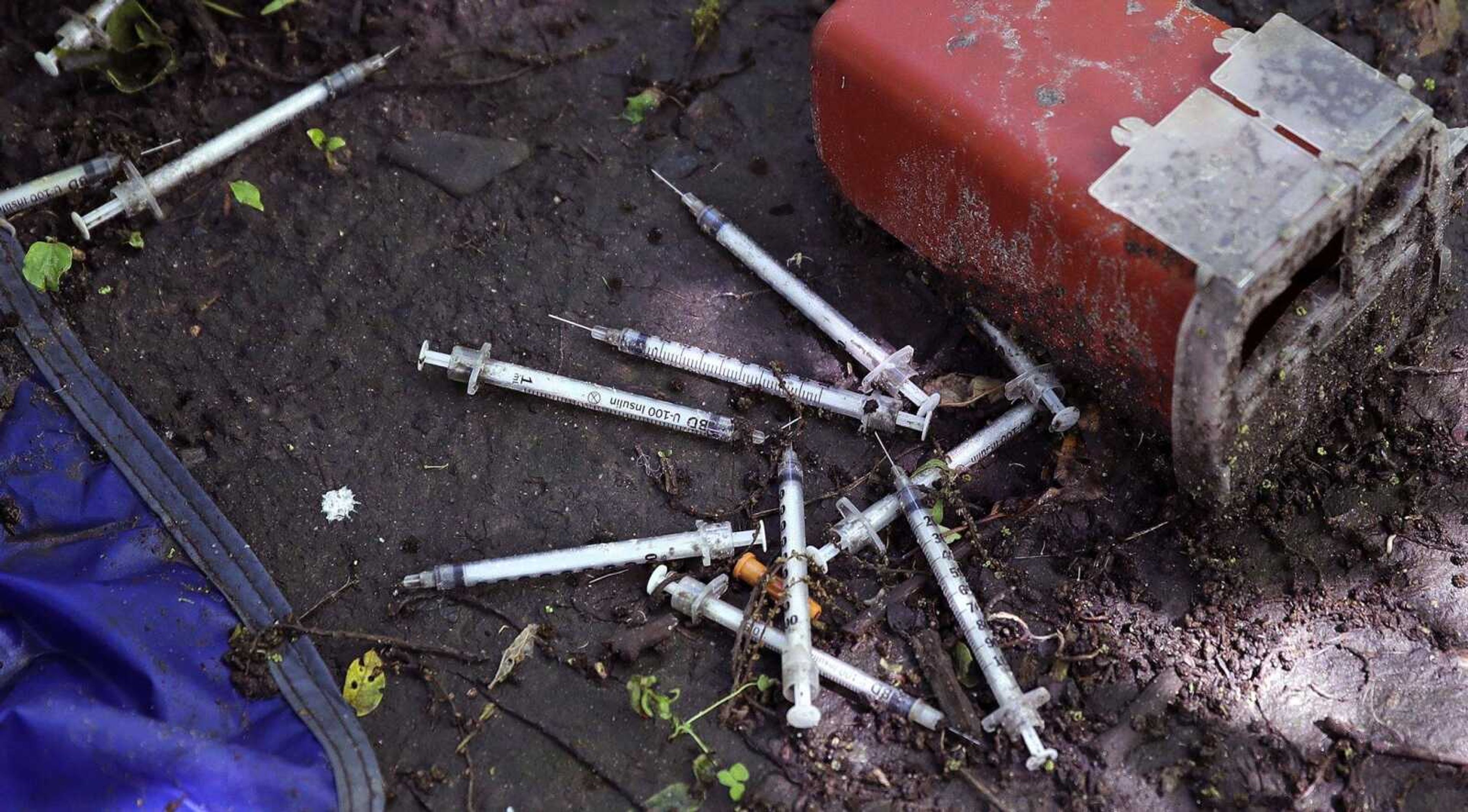 Discarded used hypodermic needles without protective sheaths are shown at an encampment where opioid addicts shoot up along the Merrimack River in Lowell, Massachusetts. Syringes left by drug users amid the heroin crisis are turning up everywhere.