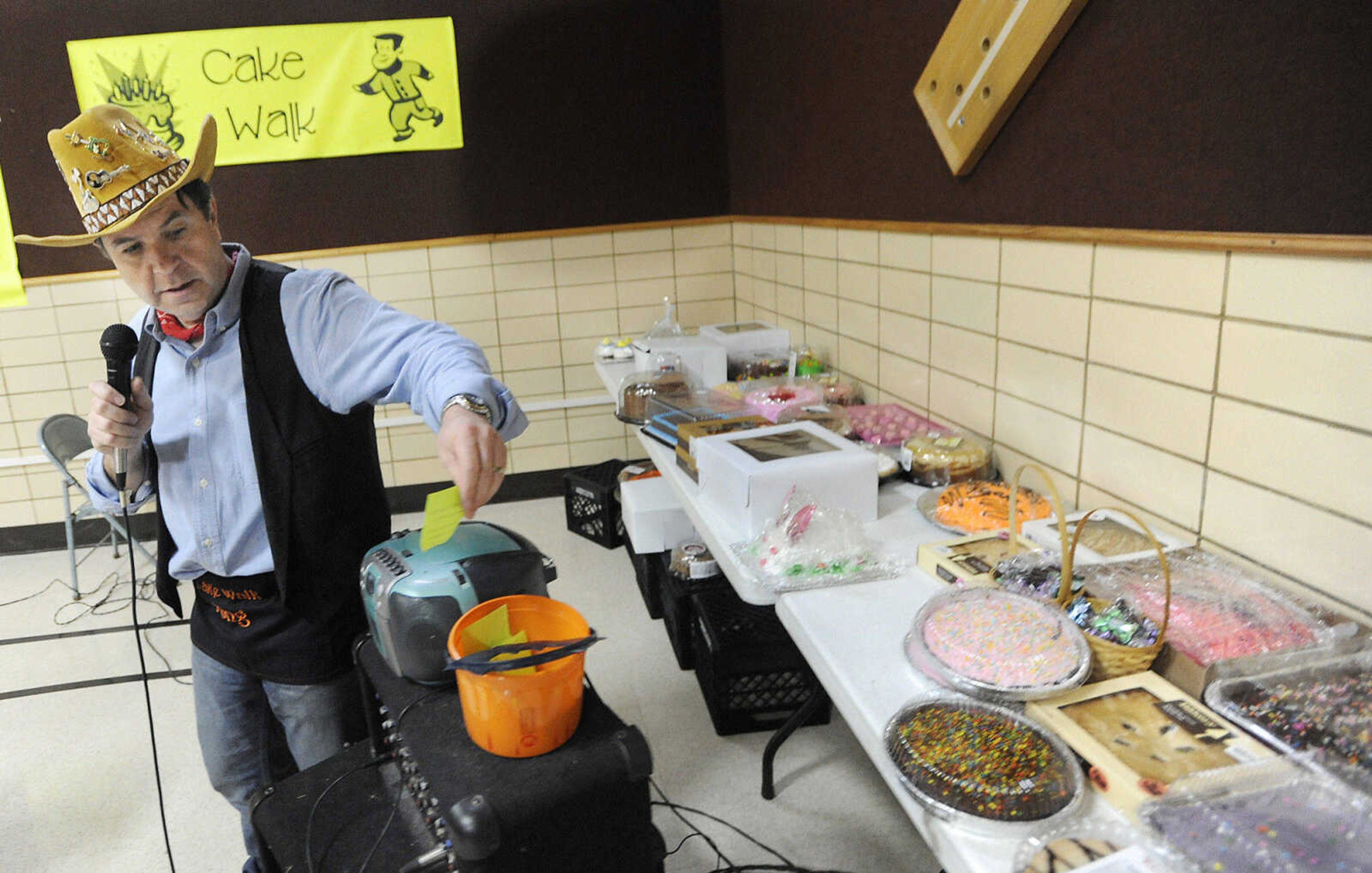 Principal Mark Cook draws a number to find out who won a round of the cake walk during the Jefferson Elementary Chili Dinner Friday night. Cook is retiring after this year.