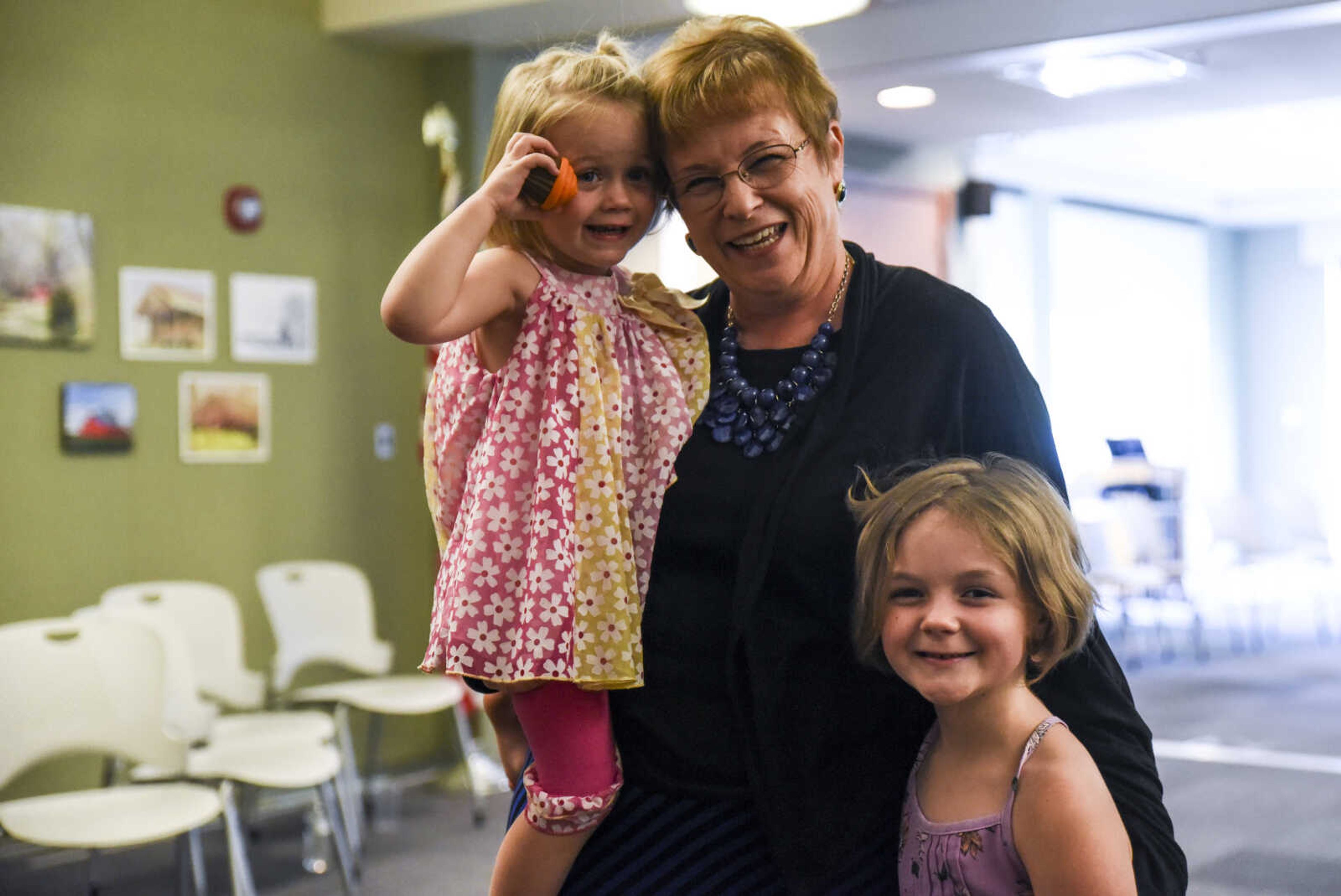 Betty Martin poses for a photo with her granddaughters Melody Murad, 2, and Lily Murad, 7, at her retirement open house Friday, July 13, 2018 at the Cape Girardeau Public Library.