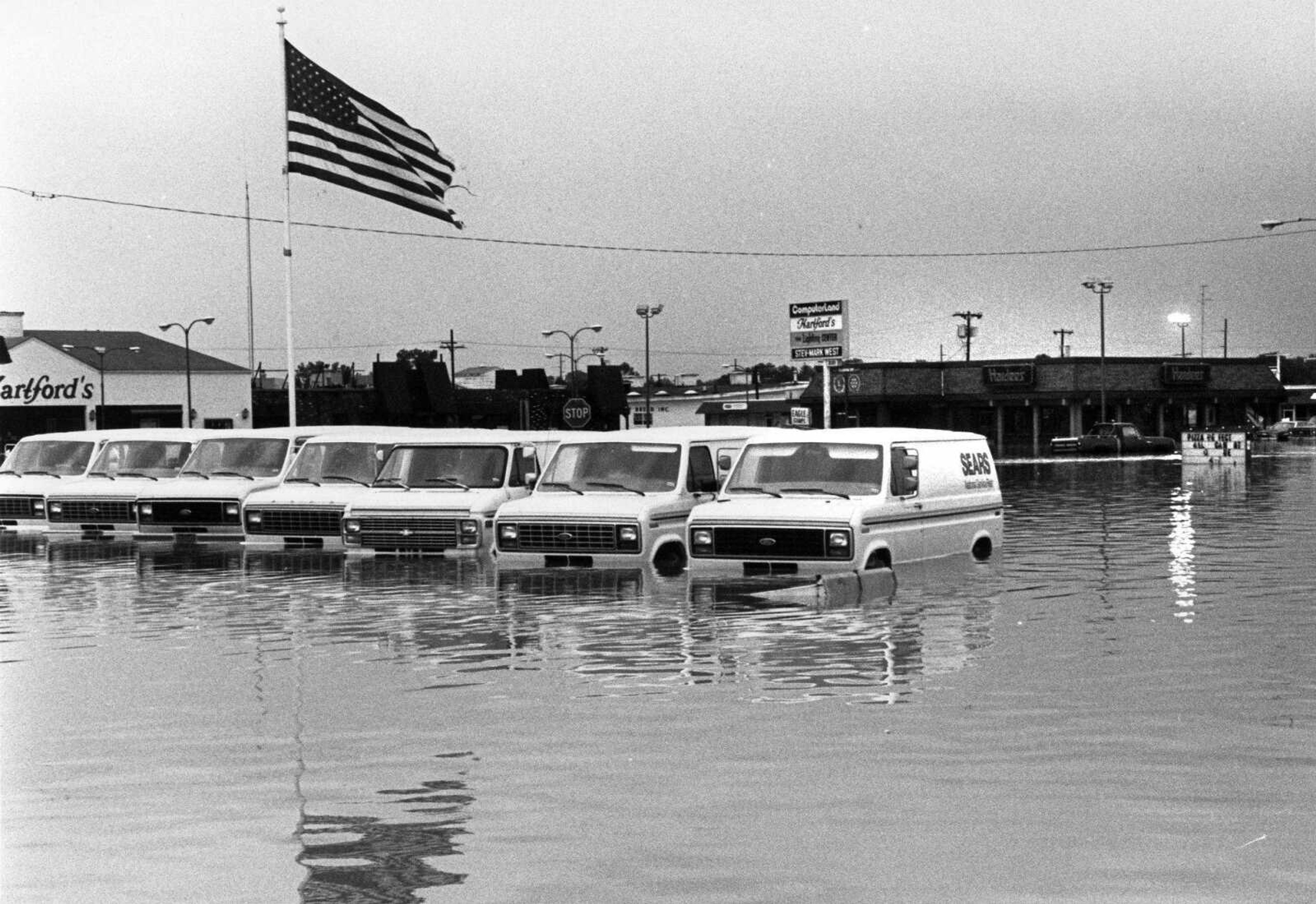 Sears vehicles are surrounded by floodwaters in the Town Plaza on May 16, 1986. (Southeast Missourian)