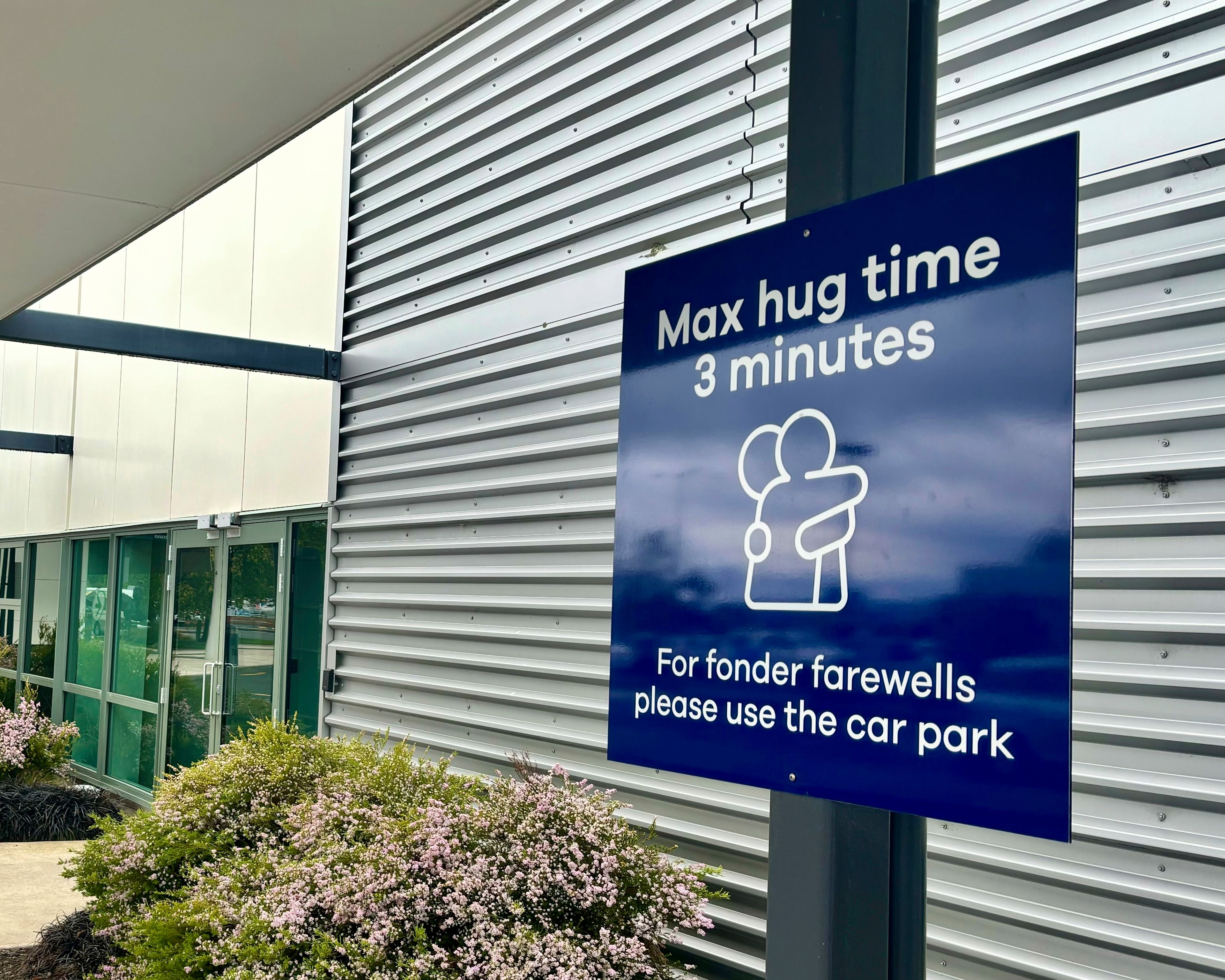 A sign informing time limits for visitors to the passenger drop-off area outside Dunedin Airport in Momona, New Zealand, Tuesday, Oct. 22, 2024. Travelers wanting to embrace for longer can relocate to the parking lot. (Sarah Soper/Dunedin Airport via AP)