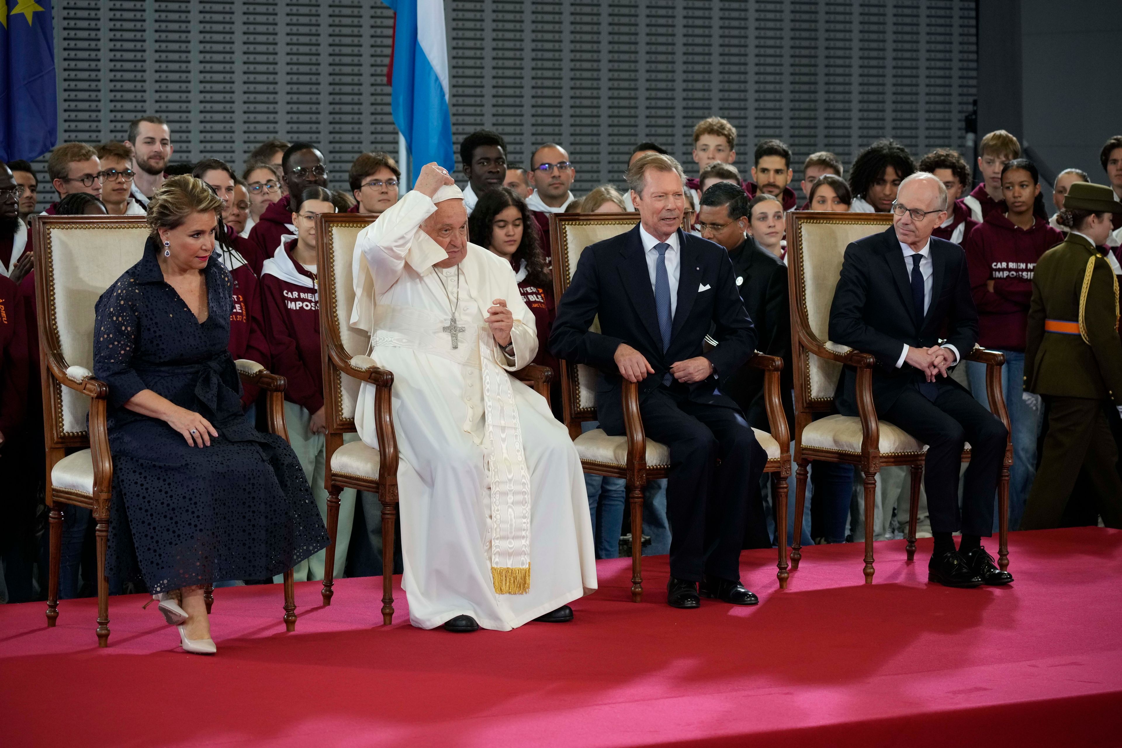 Pope Francis flanked by Grand Duchess Maria Teresa, left, Luxembourg's Grand Duke Henri, second form right, and by the Prime Minister Luc Friede attends the welcome ceremony upon his arrival at Findel International Airport in Luxembourg, Thursday, Sept. 26, 2024. (AP Photo/Andrew Medichini)