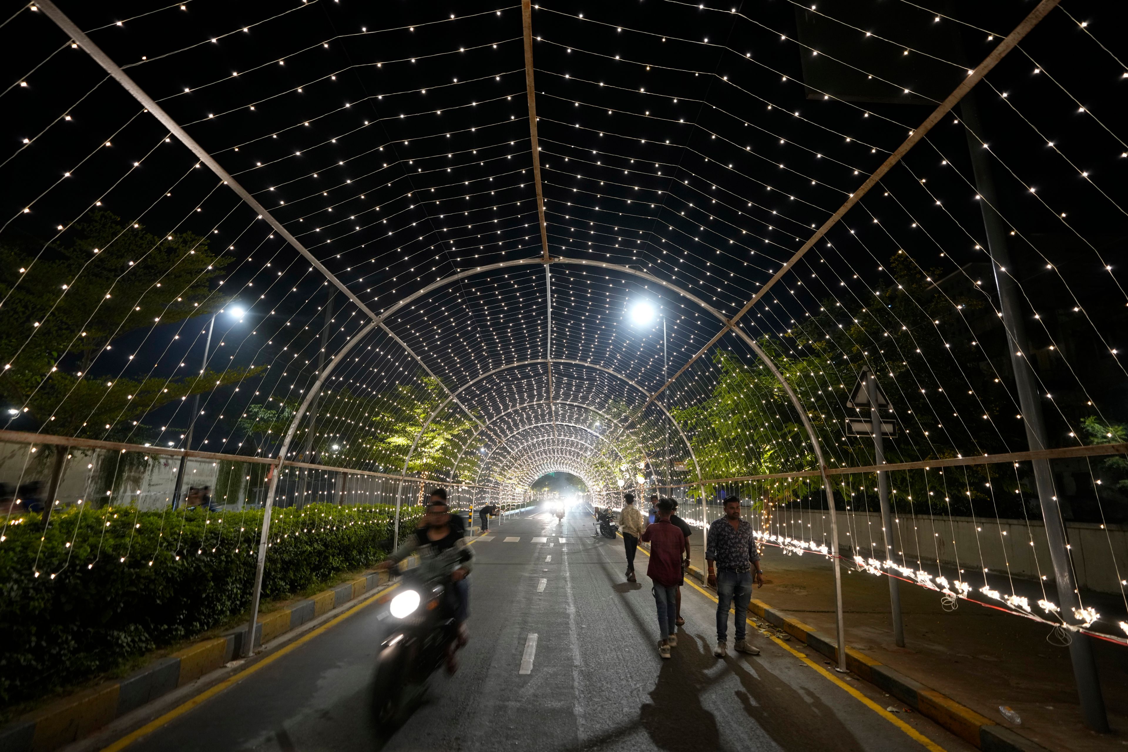 Commuters move on an illuminated road ahead of the Hindu festival of lights Diwali in Ahmedabad, India, Thursday, Oct. 31, 2024. (AP Photo/Ajit Solanki)