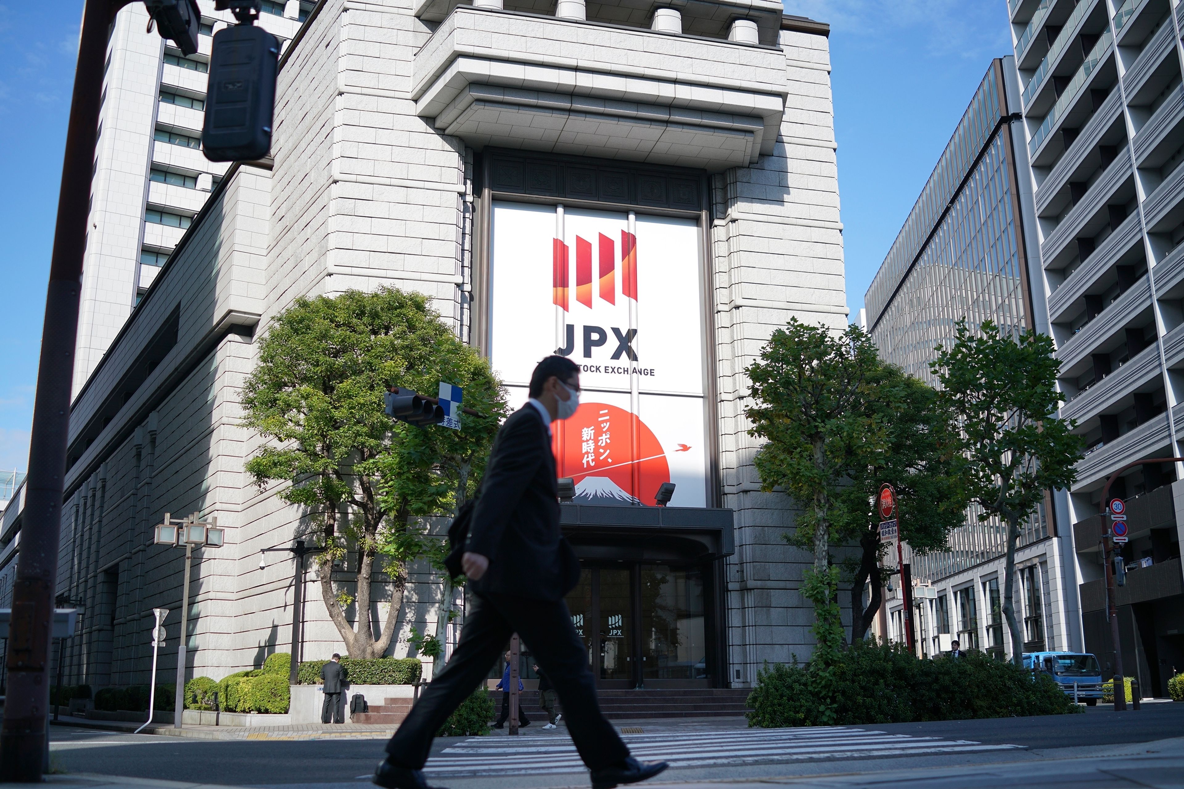 A person walks in front of the Tokyo Stock Exchange building at a securities firm Tuesday, Nov. 26, 2024, in Tokyo. (AP Photo/Eugene Hoshiko)