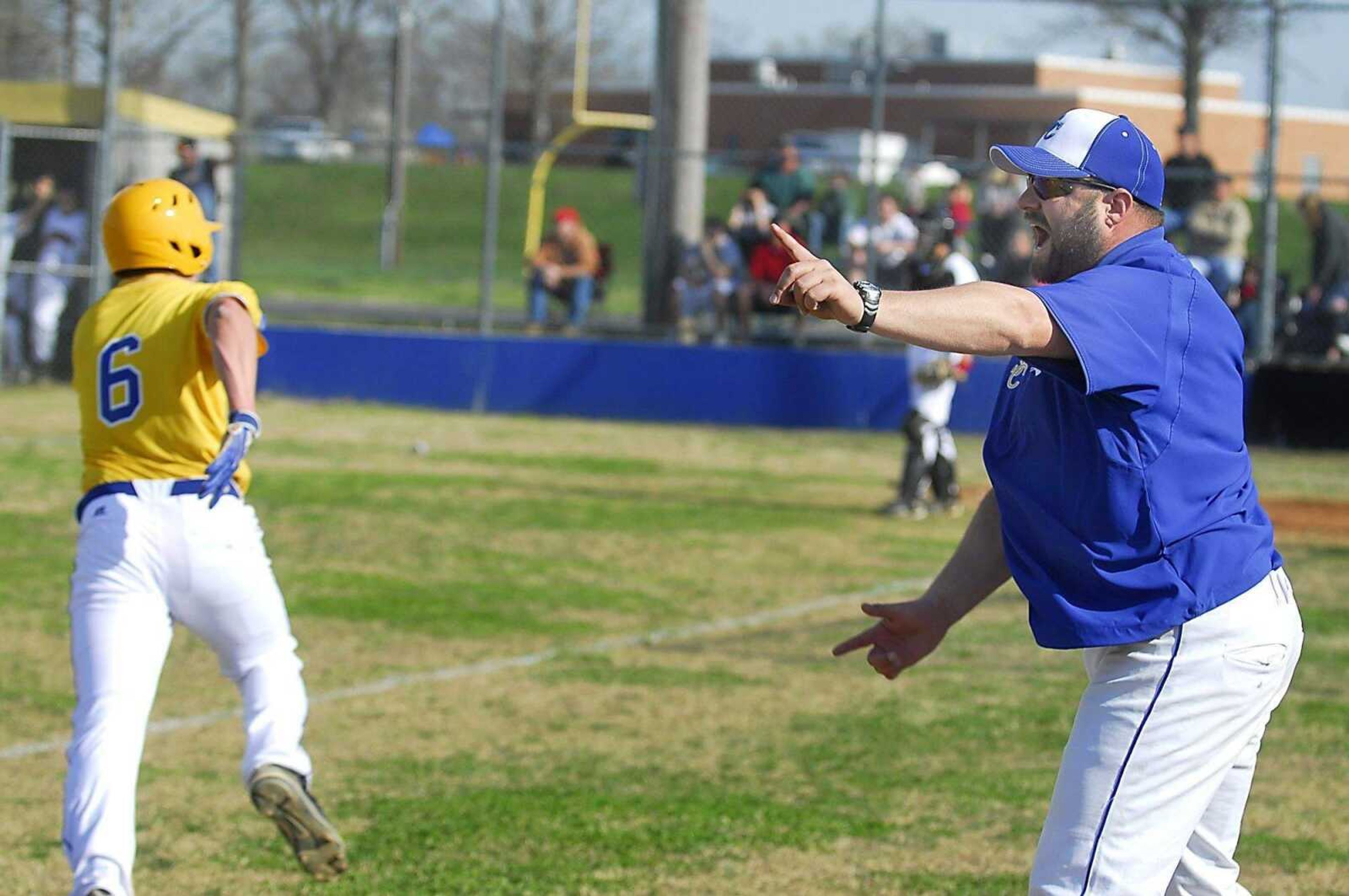 KIT DOYLE ~ kdoyle@semissourian.comScott City's Austin Raines heads to the plate as coach Lance Amick directs traffic Monday in Scott City. Raines scored on the play.