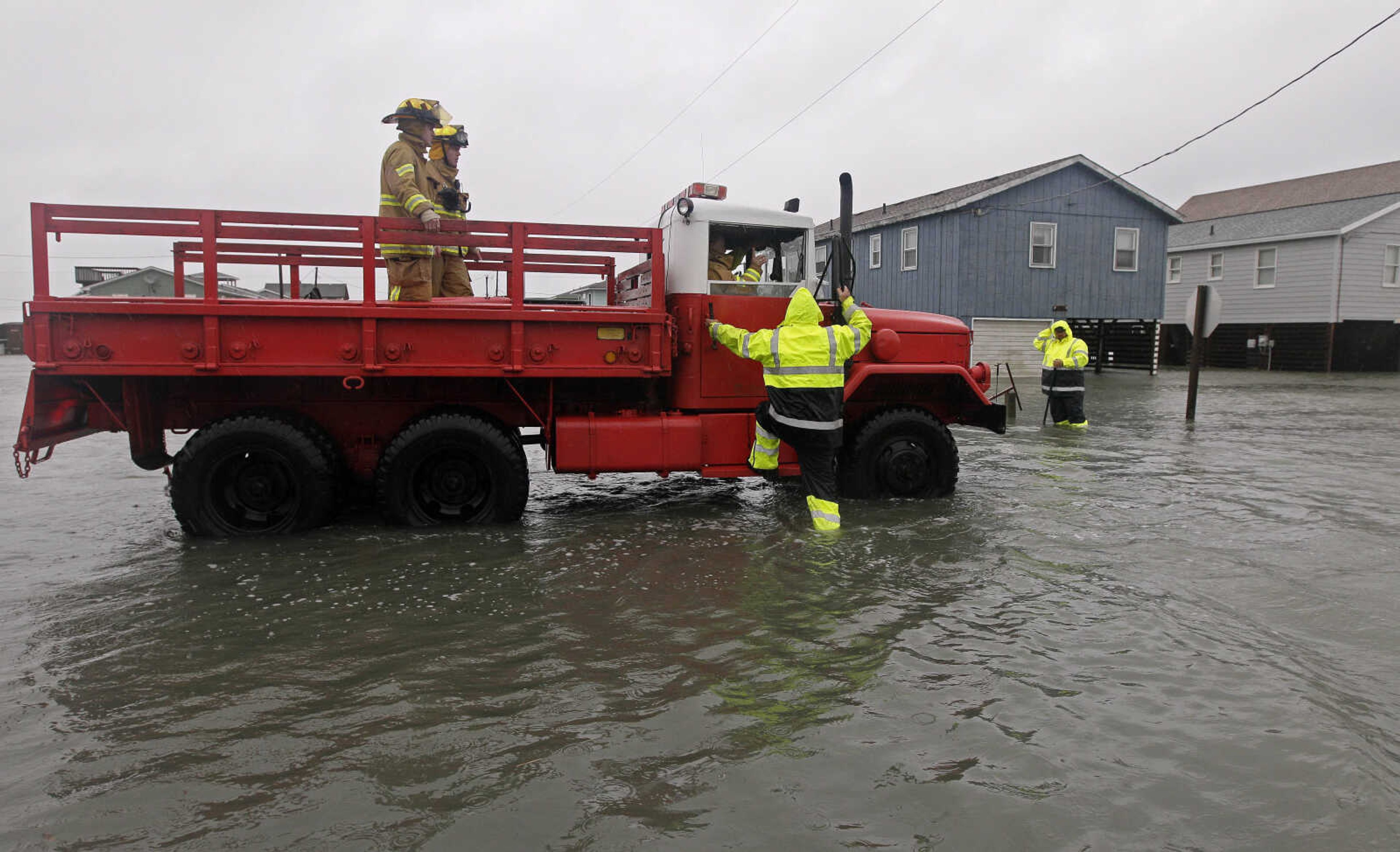 A Dare County utility worker checks with the Kitty Hawk Fire Department as they patrol flooded streets in Kitty Hawk, N.C., Monday, Oct. 29, 2012. Hurricane Sandy continued on its path Monday, as the storm forced the shutdown of mass transit, schools and financial markets, sending coastal residents fleeing, and threatening a dangerous mix of high winds and soaking rain.Ę(AP Photo/Gerry Broome)