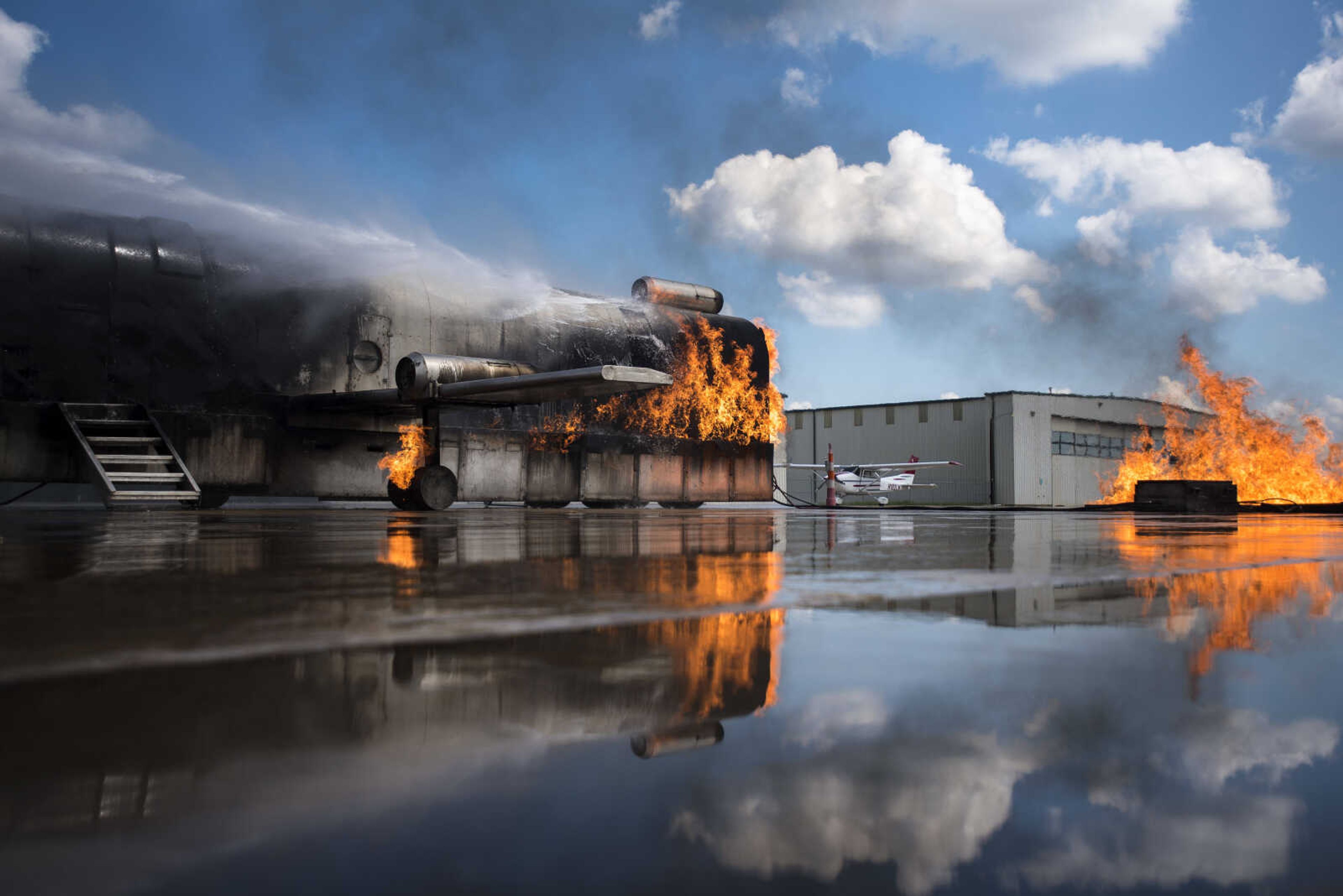 A firefighter guiding a firetruck hose puts out a ground fire and aircraft fire while area firefighters from Cape Girardeau, Gordonville and Scott City run airplane fire drills at the Cape Girardeau Regional Airport Friday morning, Sept. 15, 2017 in Cape Girardeau.